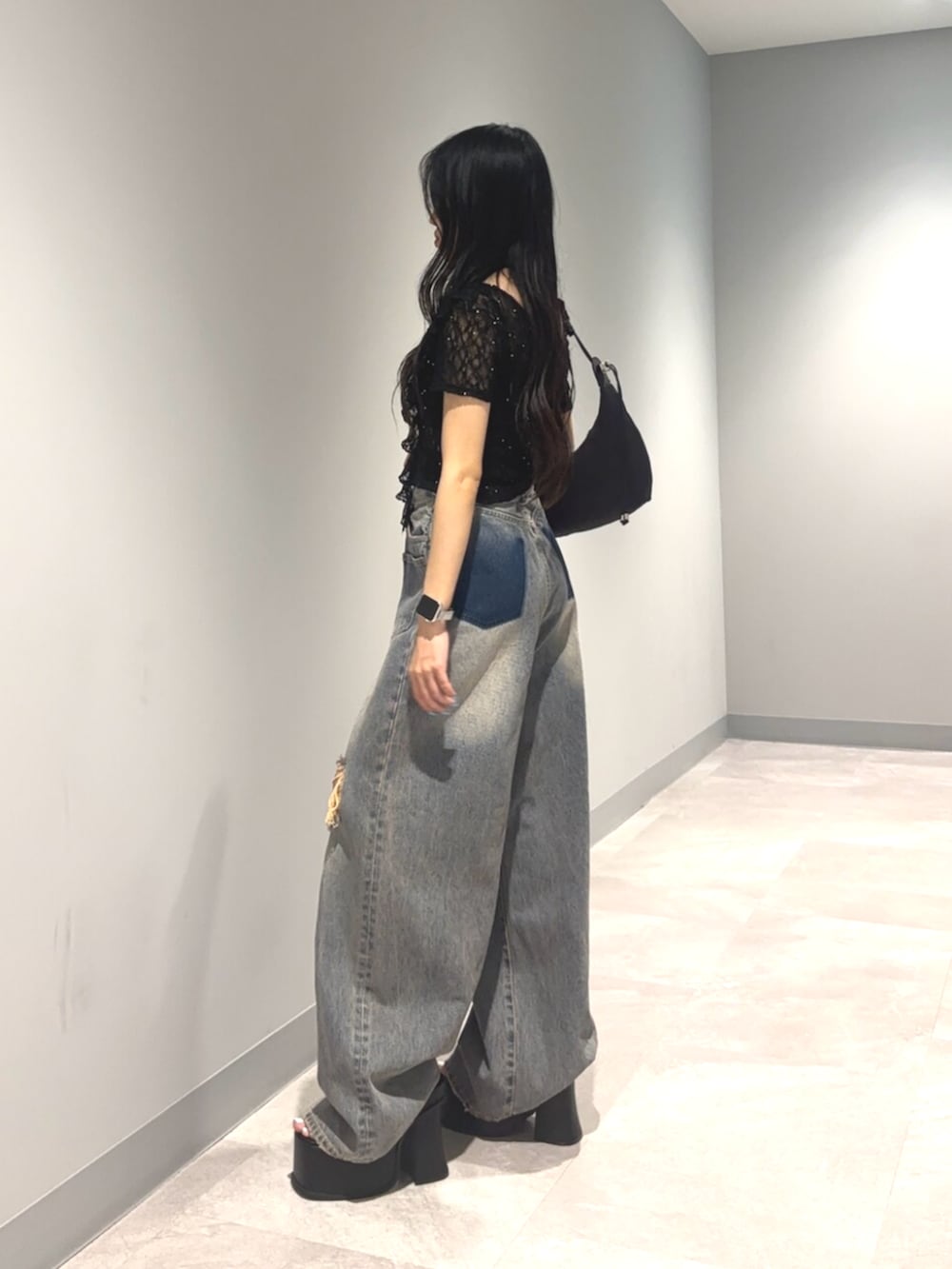 ブラック系のサンダル、ブルー系のデニムパンツ、ブラック系のTシャツ/カットソーを着用したレディースの夏コーディネートの4枚目の写真