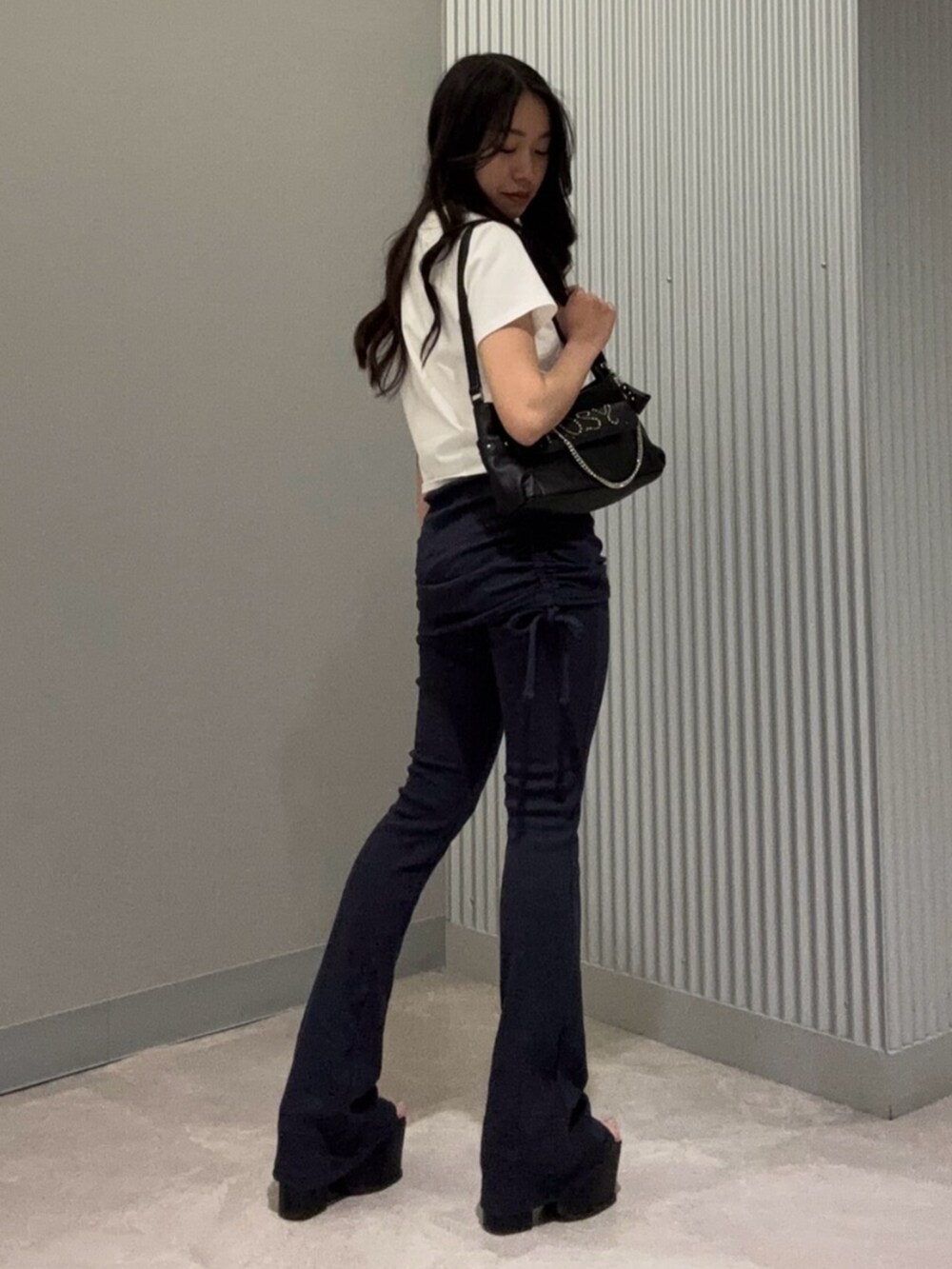 ブルー系のその他パンツ、ホワイト系のTシャツ/カットソー、ブラック系のサンダルを着用したレディースの春コーディネートの5枚目の写真