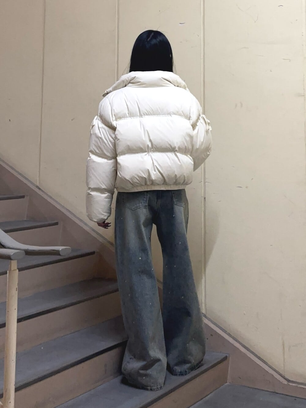 ブラック系のブーツ、ブルー系のデニムパンツ、ホワイト系のダウンジャケット/コートを着用したレディースの冬コーディネートの3枚目の写真