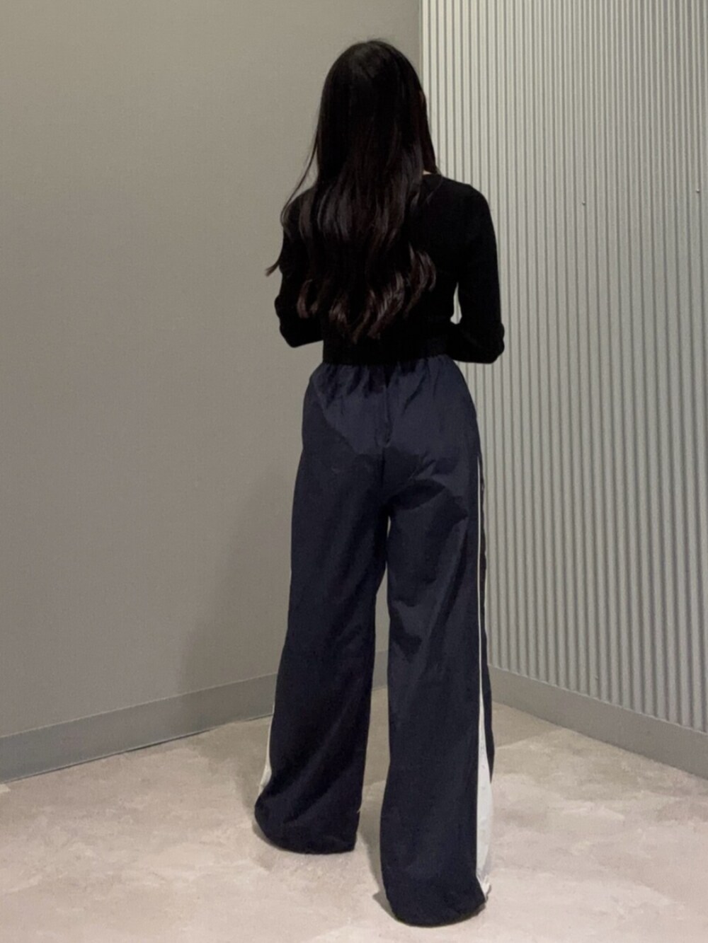 ブルー系のその他パンツ、ブラック系のニット/セーター、ホワイト系のパンプスを着用したレディースの春コーディネートの2枚目の写真