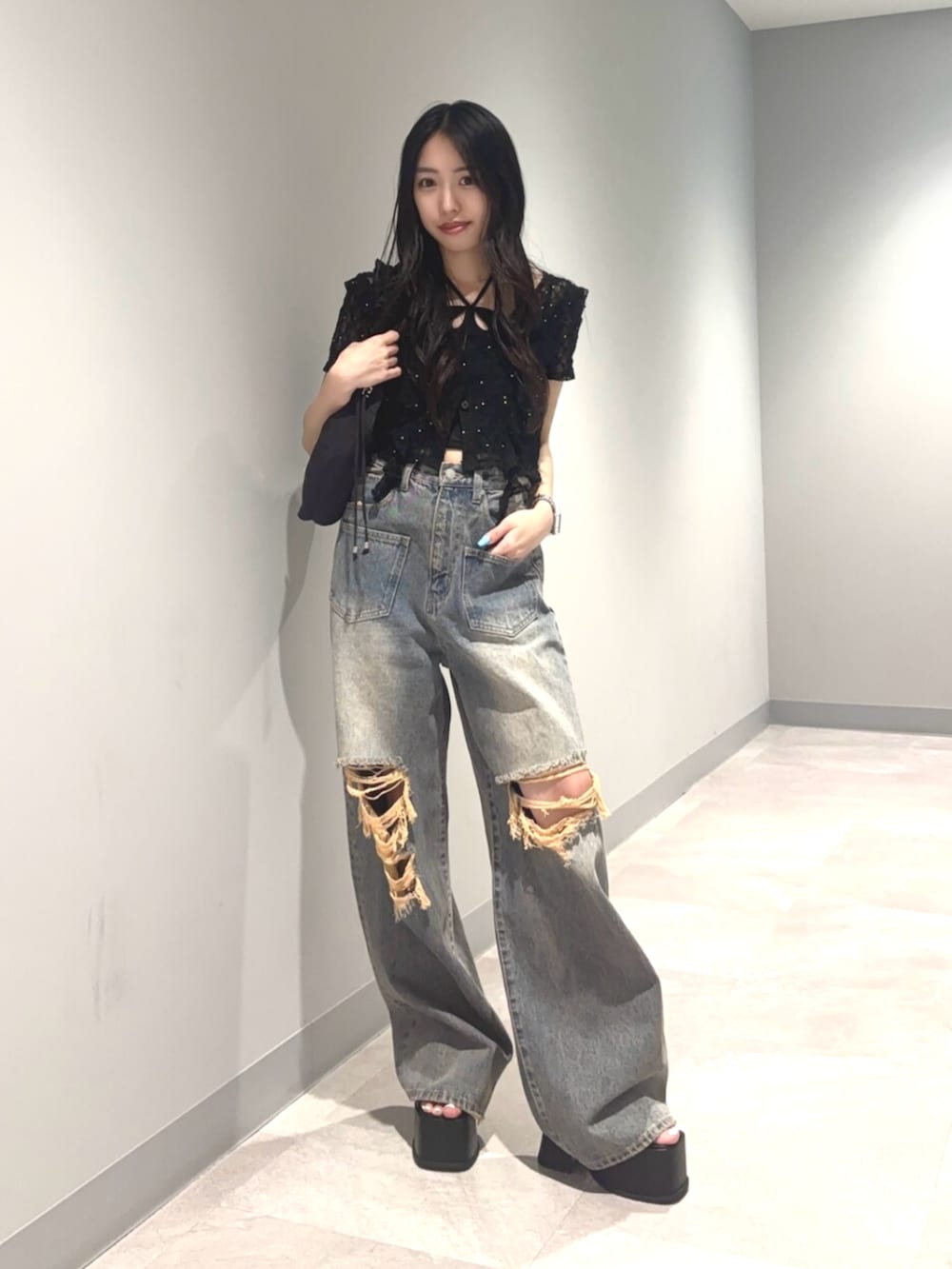 ブラック系のサンダル、ブルー系のデニムパンツ、ブラック系のTシャツ/カットソーを着用したレディースの夏コーディネートの2枚目の写真