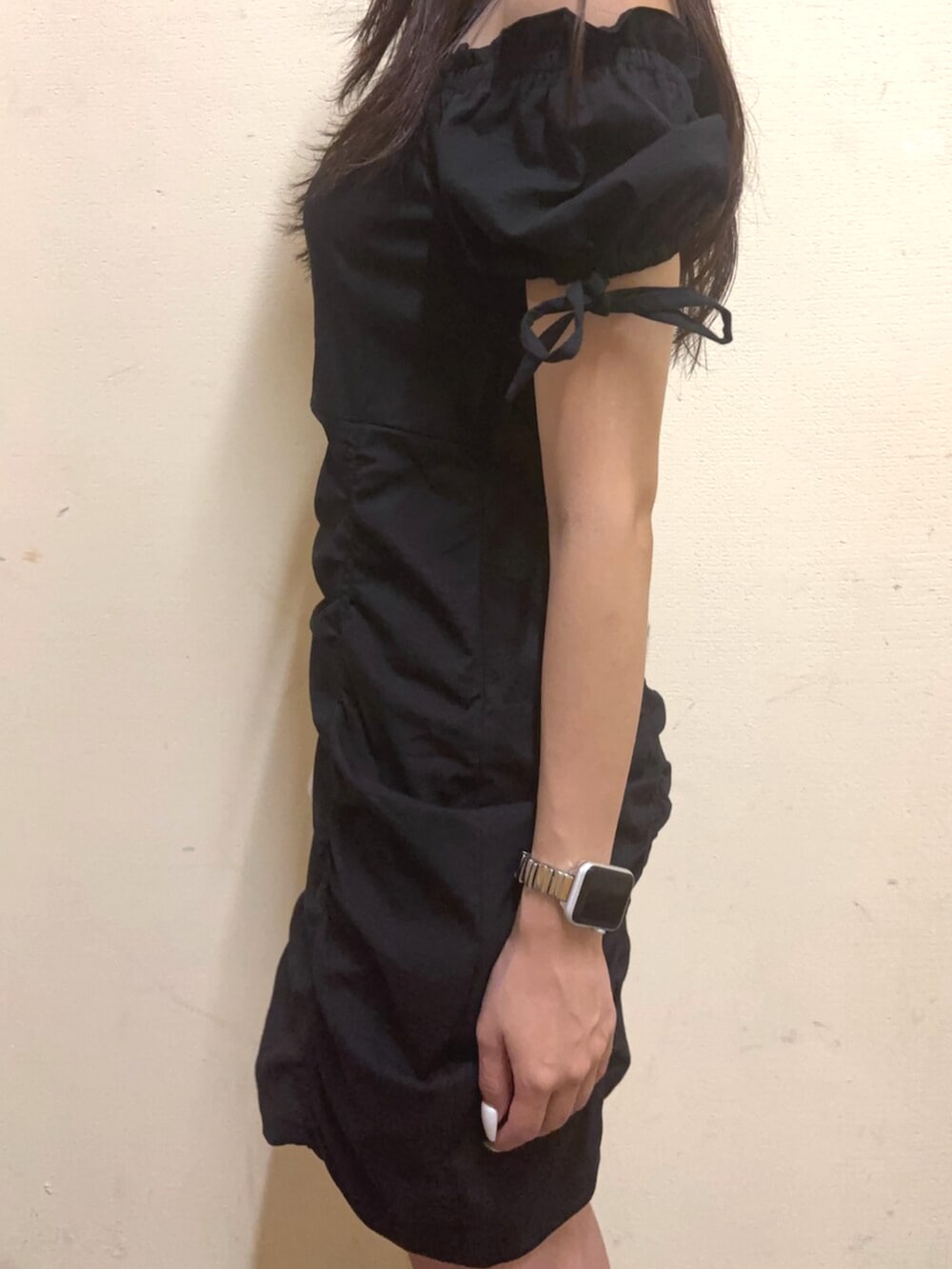 ホワイト系のハンドバッグ、ブラック系のワンピース、ブラック系のサンダルを着用したレディースの夏コーディネートの6枚目の写真