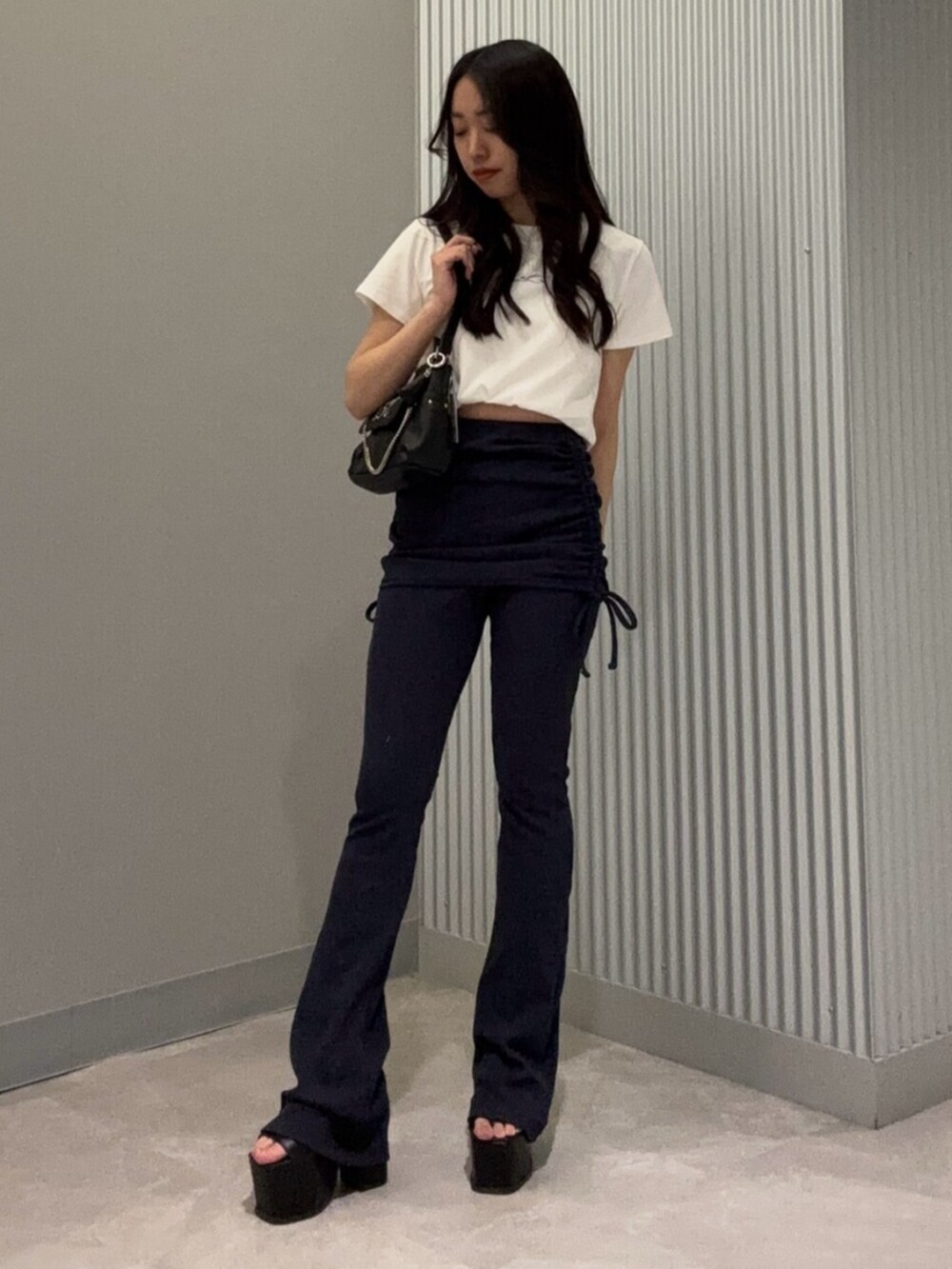 ブルー系のその他パンツ、ホワイト系のTシャツ/カットソー、ブラック系のサンダルを着用したレディースの春コーディネートの2枚目の写真