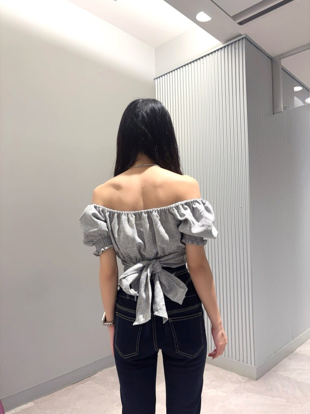 ブラック系のサンダル、ブルー系のデニムパンツを着用したレディースの夏コーディネートの5枚目の写真