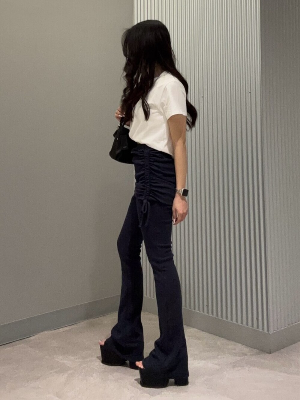 ブルー系のその他パンツ、ホワイト系のTシャツ/カットソー、ブラック系のサンダルを着用したレディースの春コーディネートの3枚目の写真