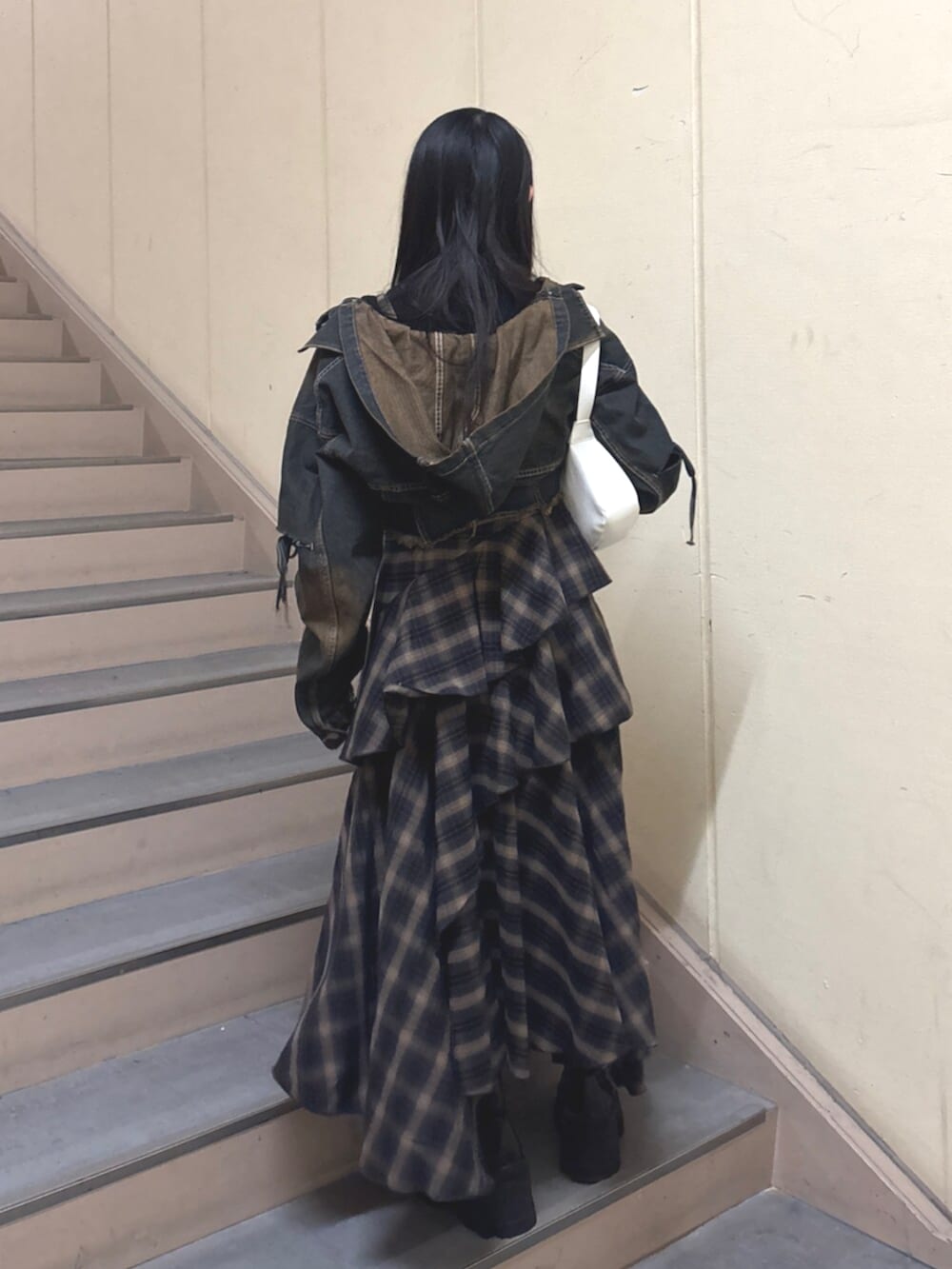 ブラック系のブーツ、ブルー系のデニムジャケット、ブルー系のワンピースを着用したレディースの春コーディネートの4枚目の写真