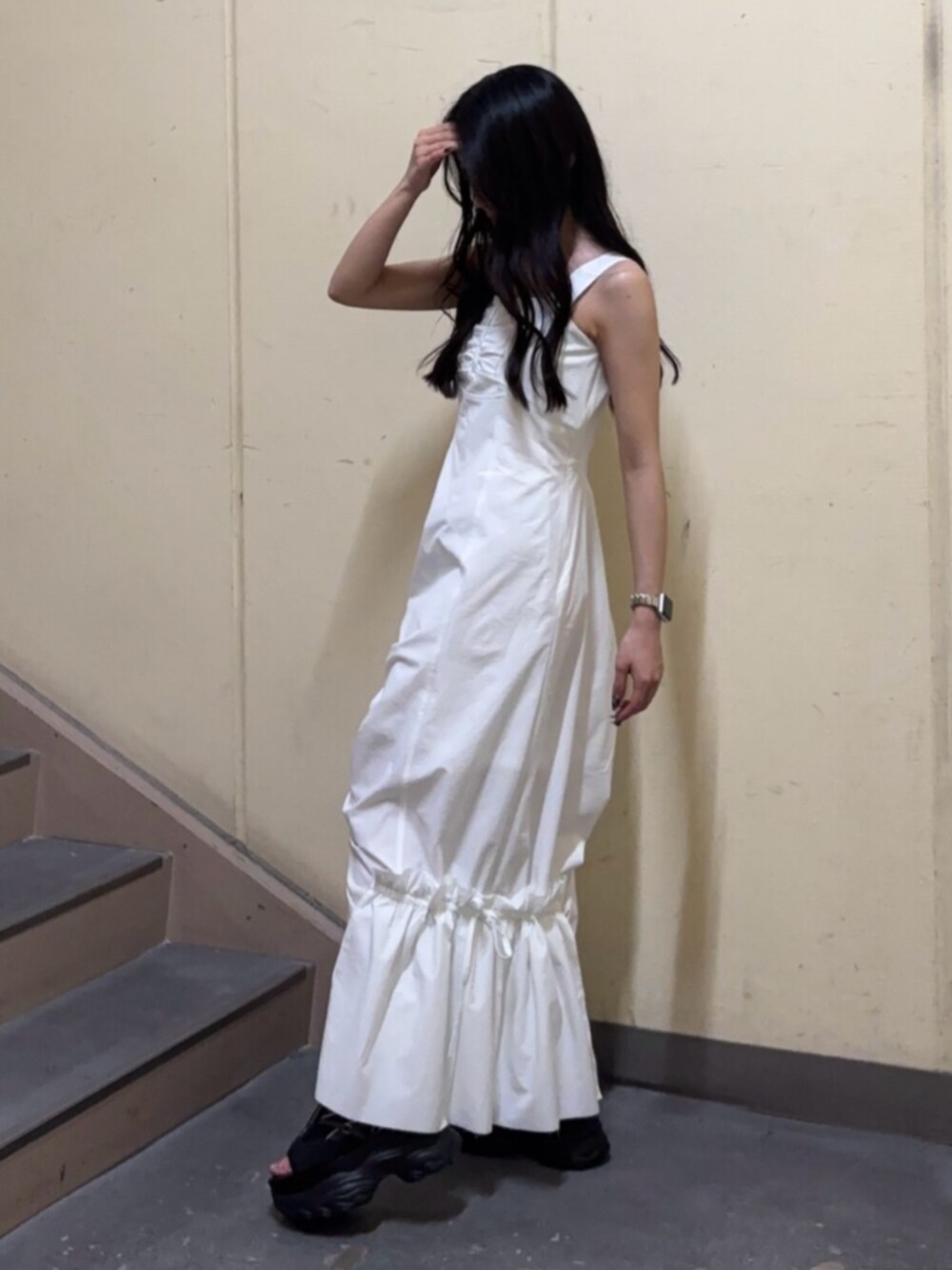 ブラック系のサンダル、ホワイト系のワンピースを着用したレディースの春コーディネートの2枚目の写真