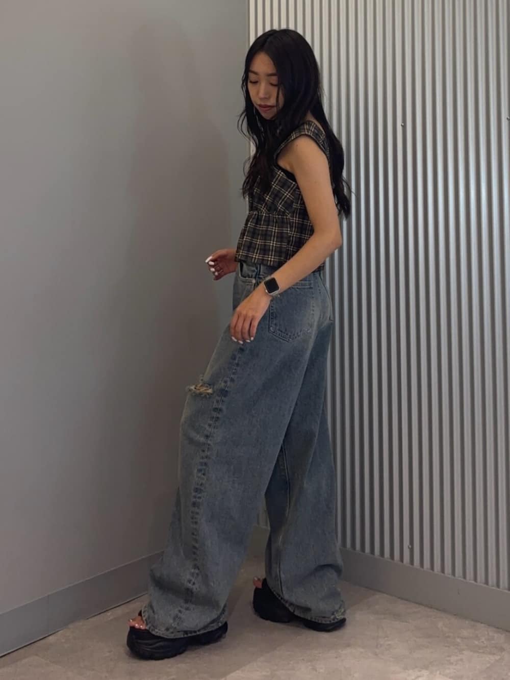 ブラック系のサンダル、ブルー系のデニムパンツ、ブラウン系のタンクトップを着用したレディースの夏コーディネートの2枚目の写真