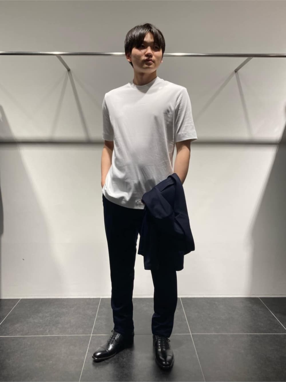 ブルー系のテーラードジャケット、ブルー系のスラックス、ホワイト系のTシャツ/カットソーを着用したメンズの春コーディネートの2枚目の写真