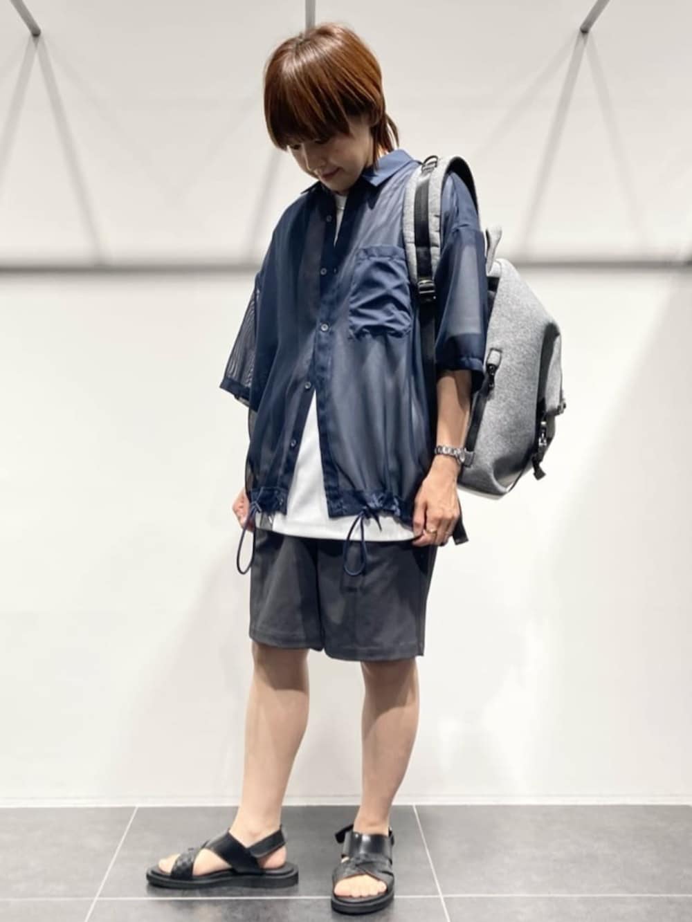 グレー系のボディバッグ/ウエストポーチ、ホワイト系のTシャツ/カットソー、ブラック系のサンダルを着用したレディースの春コーディネートの2枚目の写真