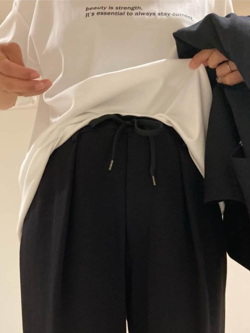 ホワイト系のTシャツ/カットソー、ブラック系のサンダル、ブラック系のその他パンツを着用したレディースの夏コーディネートの6枚目の写真