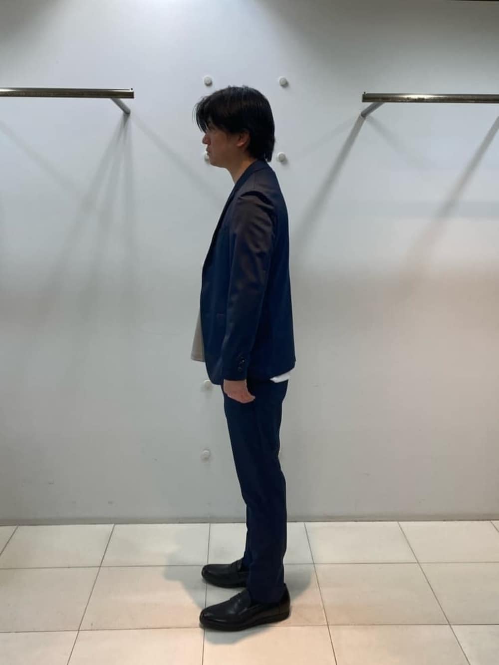 ブルー系のテーラードジャケット、ブルー系のスラックス、ホワイト系のTシャツ/カットソーを着用したメンズの冬コーディネートの2枚目の写真