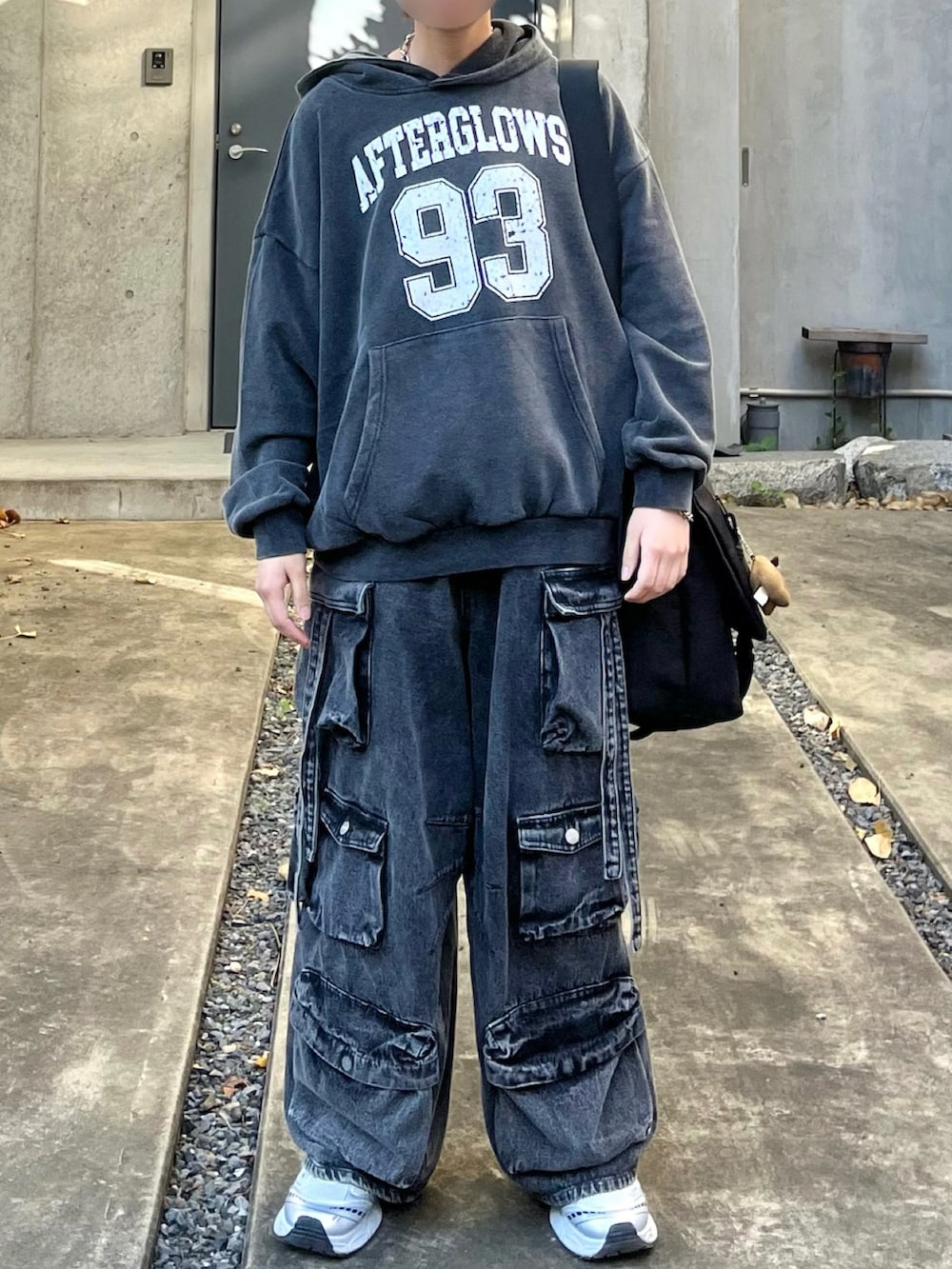 ブラック系のパーカー、ブラック系のショルダーバッグ、ブラック系のカーゴパンツを着用したメンズの秋コーディネートの3枚目の写真