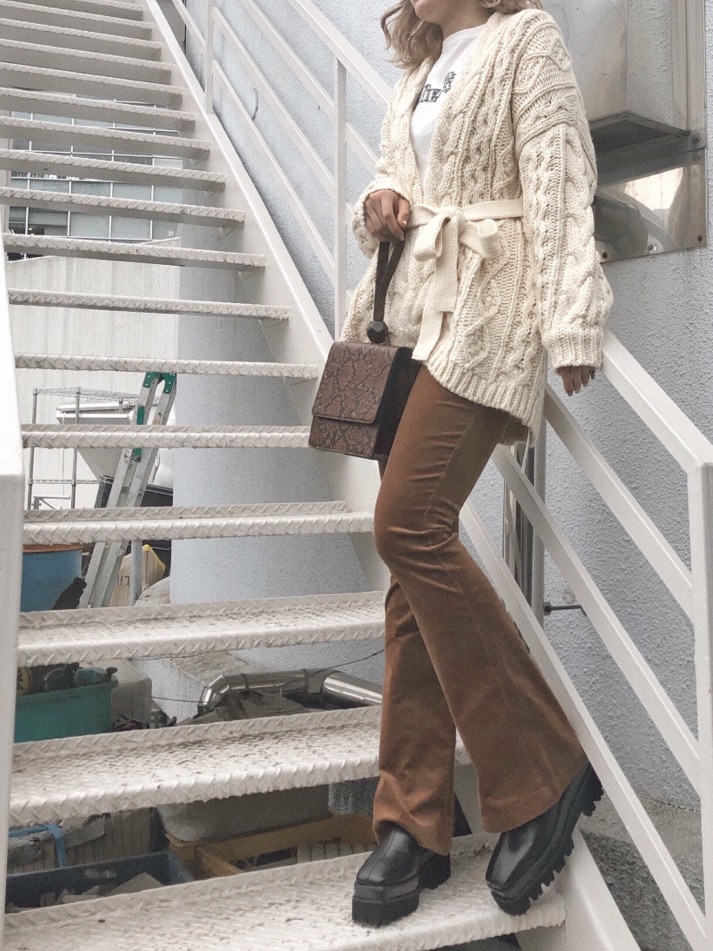 ホワイト系のTシャツ/カットソー、ホワイト系のカーディガン/ボレロ、ブラック系のブーツを着用したレディースの秋コーディネートの3枚目の写真