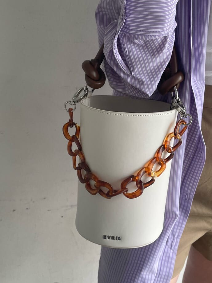 ブラック系のブーツ、ベージュ系のその他パンツ、ホワイト系のショルダーバッグを着用したレディースの春コーディネートの7枚目の写真