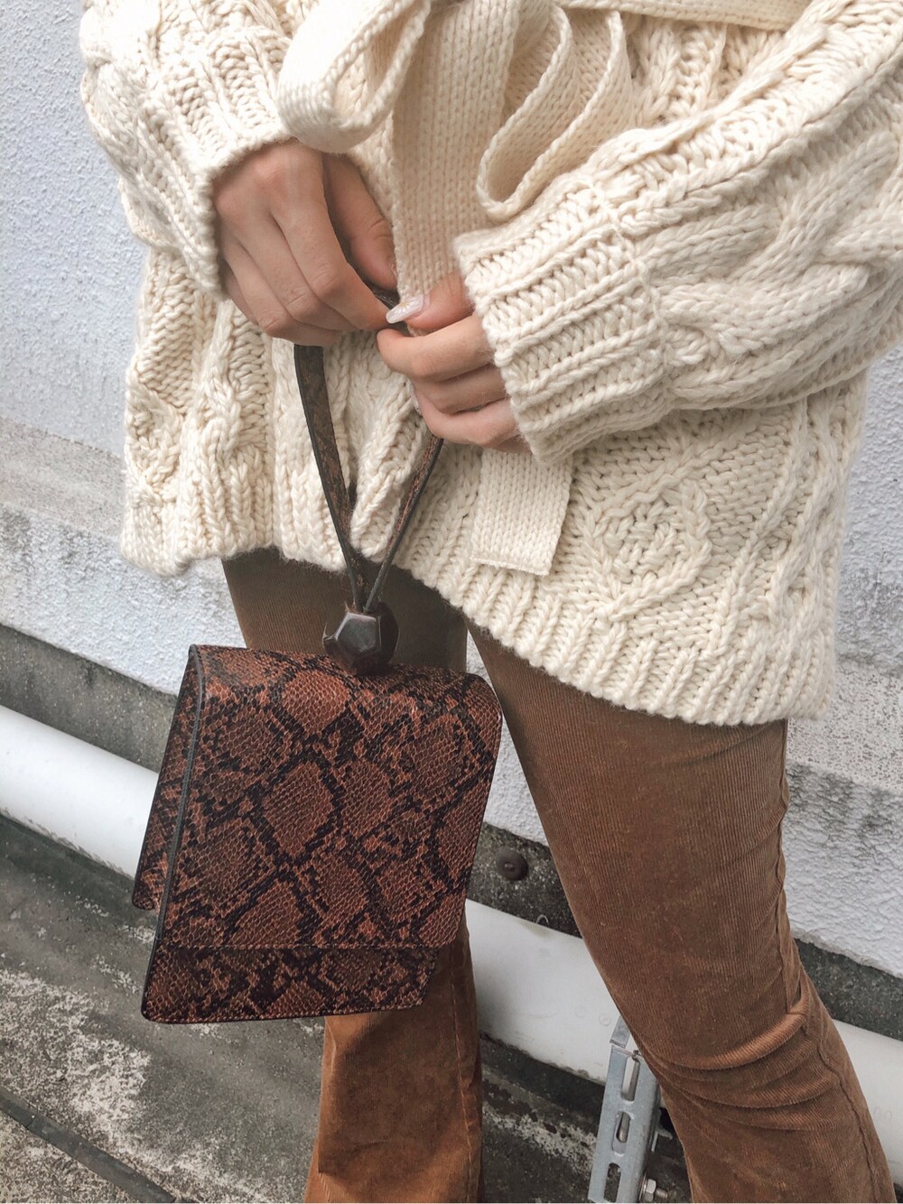 ホワイト系のTシャツ/カットソー、ホワイト系のカーディガン/ボレロ、ブラック系のブーツを着用したレディースの秋コーディネートの2枚目の写真