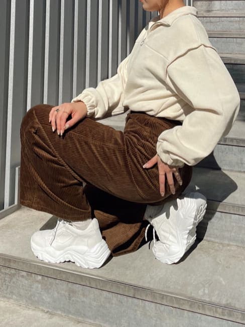 ブラウン系のその他パンツ、ホワイト系のスウェット、ホワイト系のスニーカーを着用したレディースの秋コーディネートの3枚目の写真
