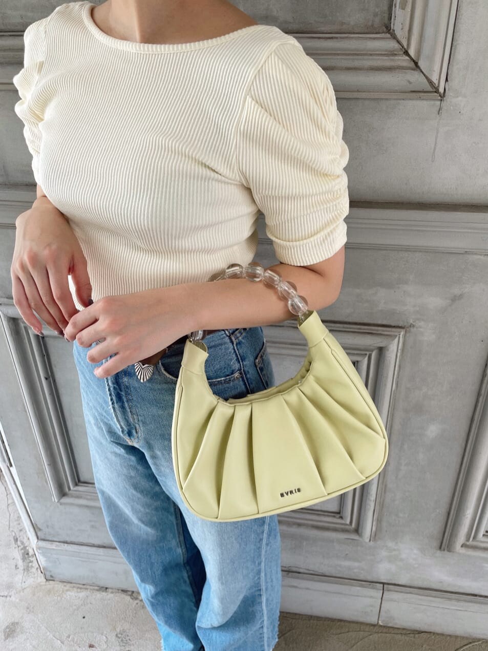 ホワイト系のTシャツ/カットソー、ブルー系のデニムパンツ、イエロー系のハンドバッグを着用したレディースの夏コーディネートの6枚目の写真