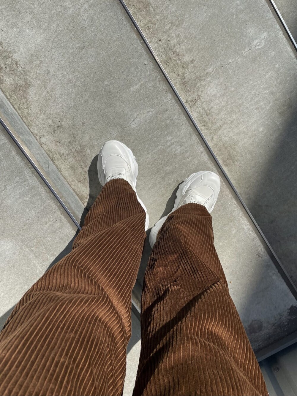 ブラウン系のその他パンツ、ホワイト系のスウェット、ホワイト系のスニーカーを着用したレディースの秋コーディネートの7枚目の写真