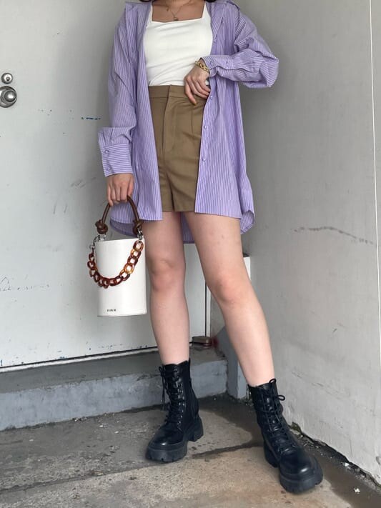 ブラック系のブーツ、ベージュ系のその他パンツ、ホワイト系のショルダーバッグを着用したレディースの春コーディネートの2枚目の写真