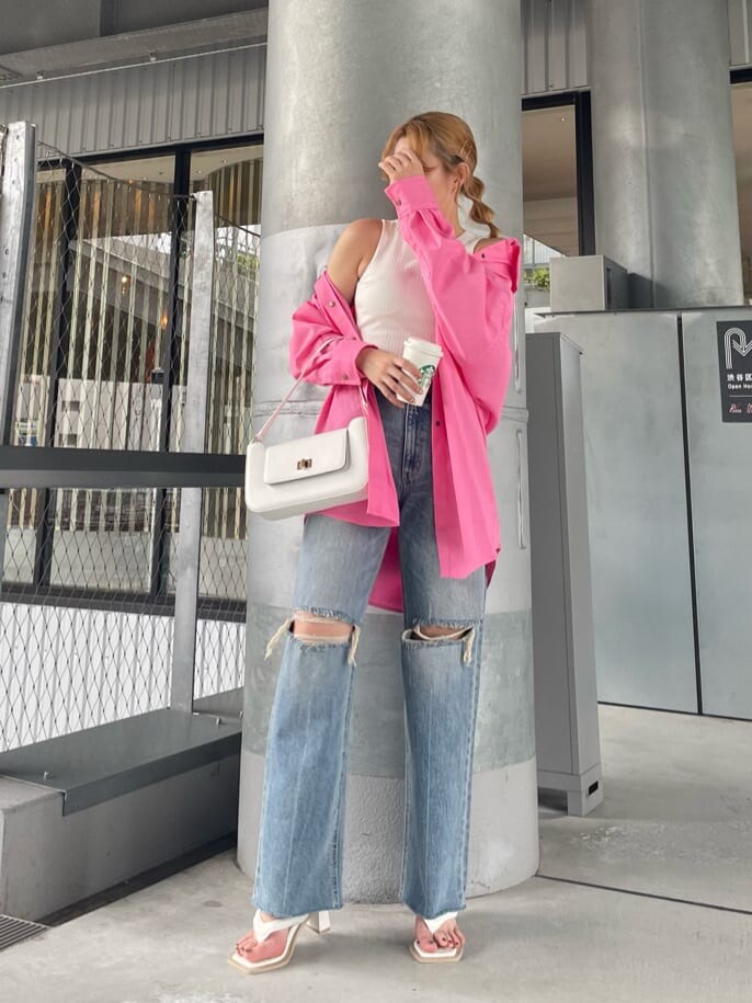 ブルー系のデニムパンツ、ホワイト系のサンダル、ホワイト系のショルダーバッグを着用したレディースの夏コーディネートの2枚目の写真