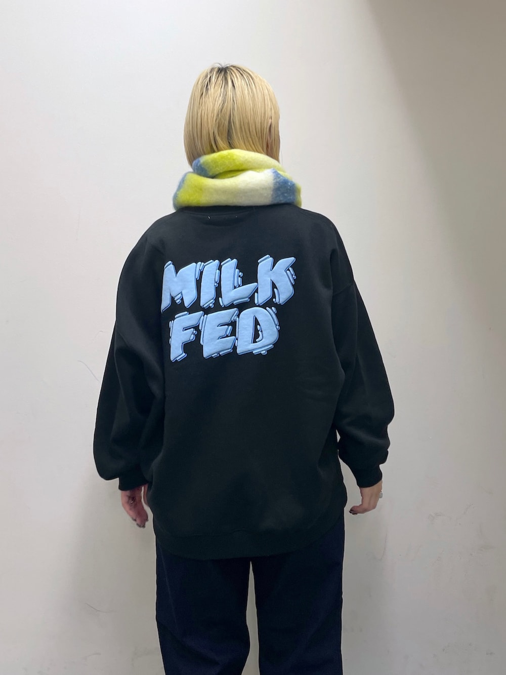 ブルー系のデニムパンツ、グリーン系のバックパック/リュック、ブラック系のスウェットを着用したレディースの秋コーディネートの6枚目の写真