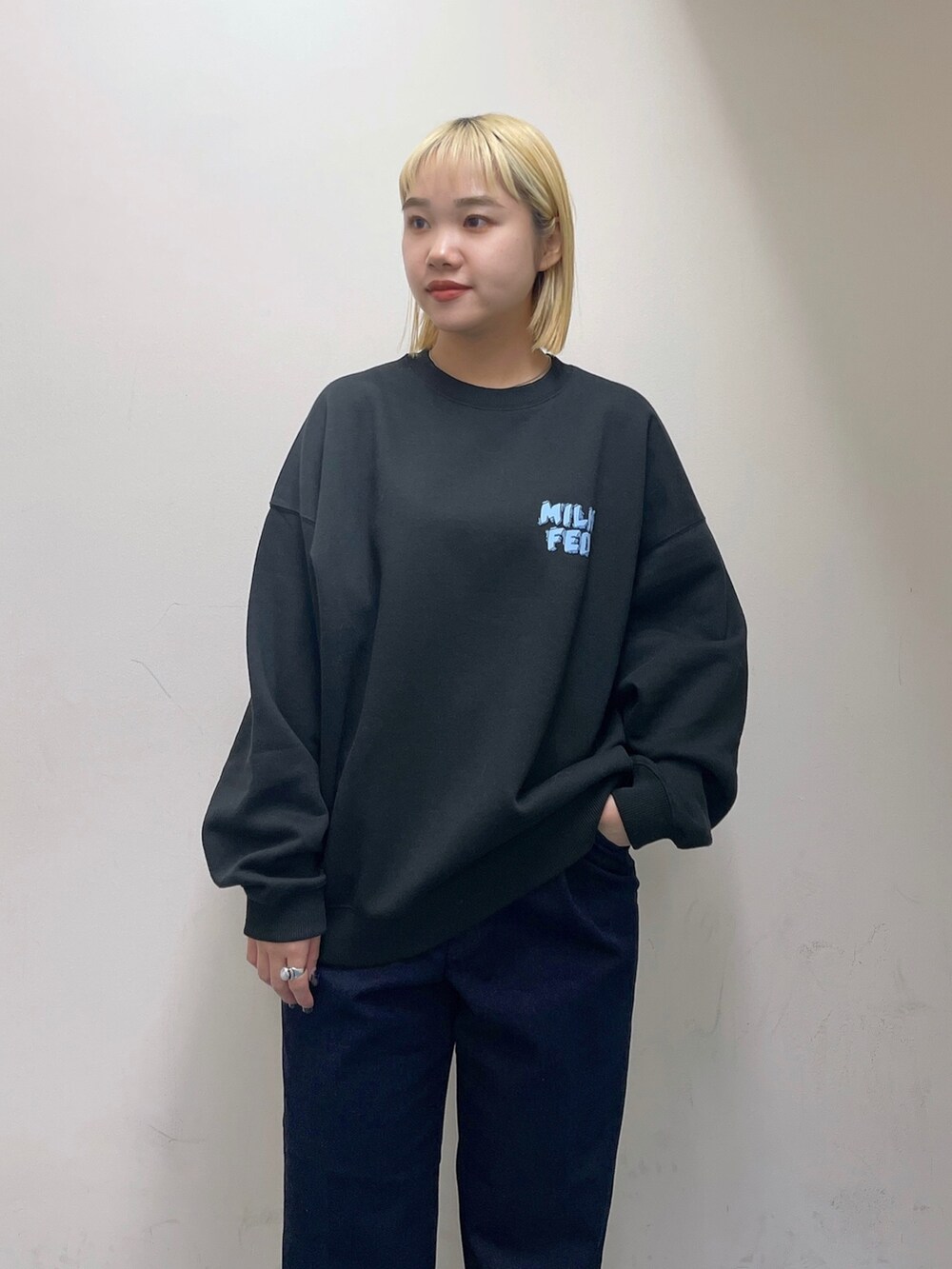 ブルー系のデニムパンツ、グリーン系のバックパック/リュック、ブラック系のスウェットを着用したレディースの秋コーディネートの7枚目の写真