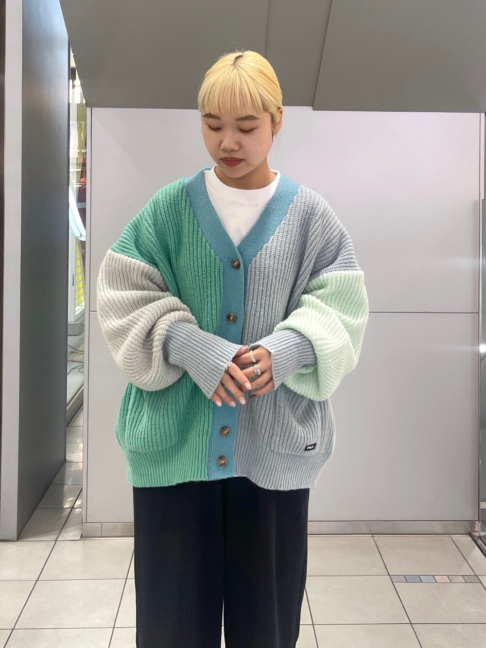 ブラック系のスウェットパンツ、ブルー系のトートバッグ、グリーン系のカーディガン/ボレロを着用したレディースの冬コーディネートの7枚目の写真