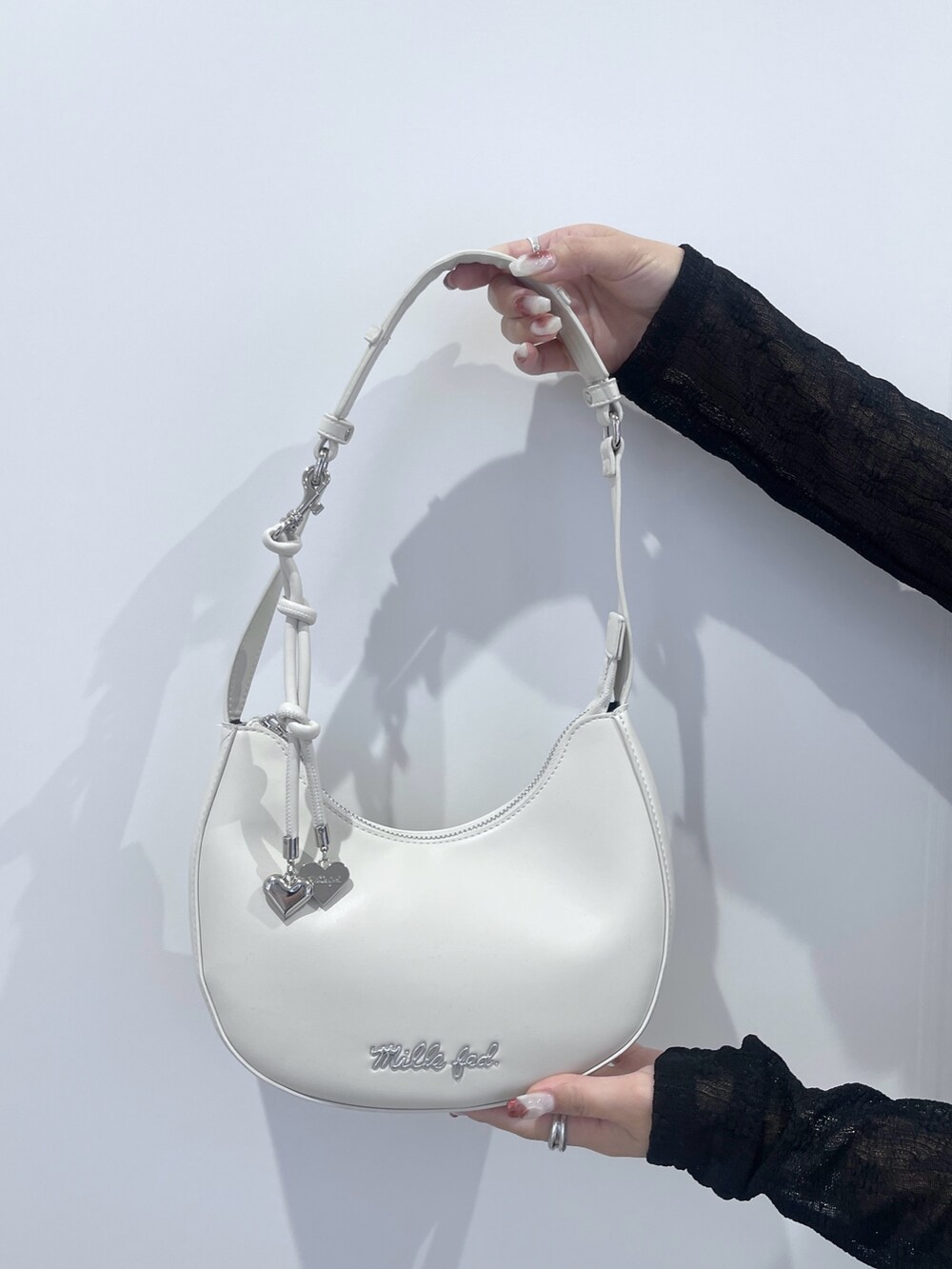 ブラック系のTシャツ/カットソー、ブラック系のスカート、ホワイト系のハンドバッグを着用したレディースの秋コーディネートの10枚目の写真