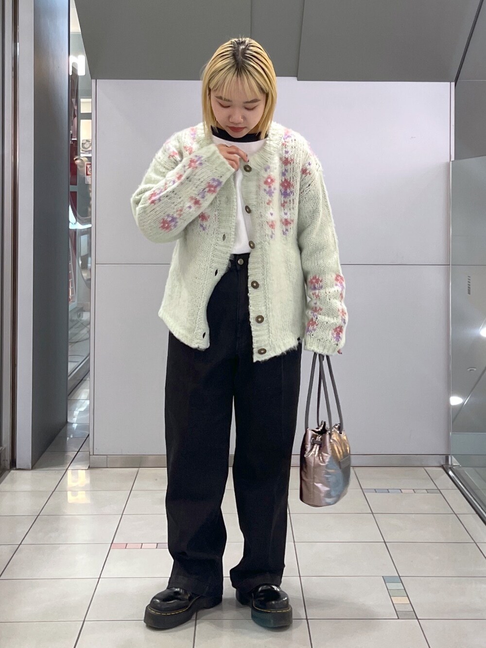 ブラック系のデニムパンツ、グリーン系のカーディガン/ボレロ、ブラック系のTシャツ/カットソーを着用したレディースの冬コーディネートの2枚目の写真