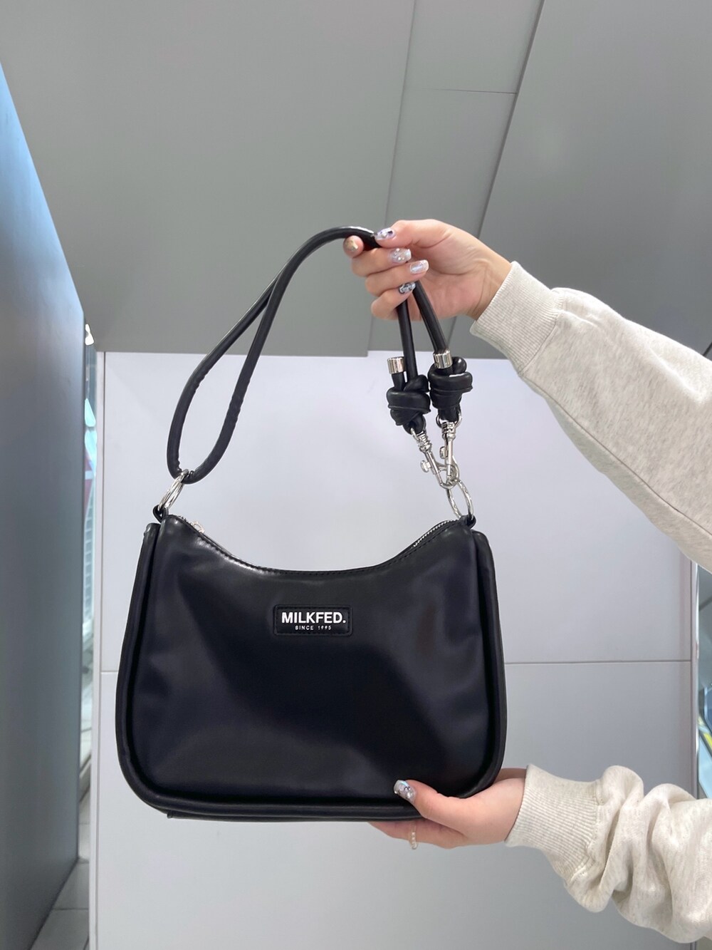 レッド系のスカート、ベージュ系のスウェット、ブラック系のショルダーバッグを着用したレディースの冬コーディネートの10枚目の写真