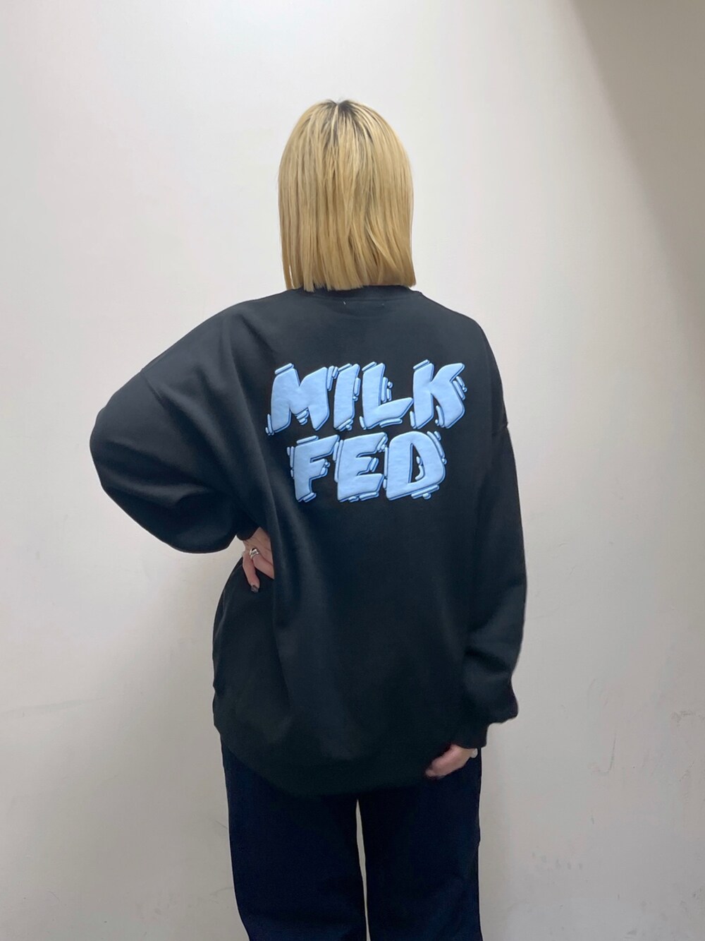 ブルー系のデニムパンツ、グリーン系のバックパック/リュック、ブラック系のスウェットを着用したレディースの秋コーディネートの8枚目の写真