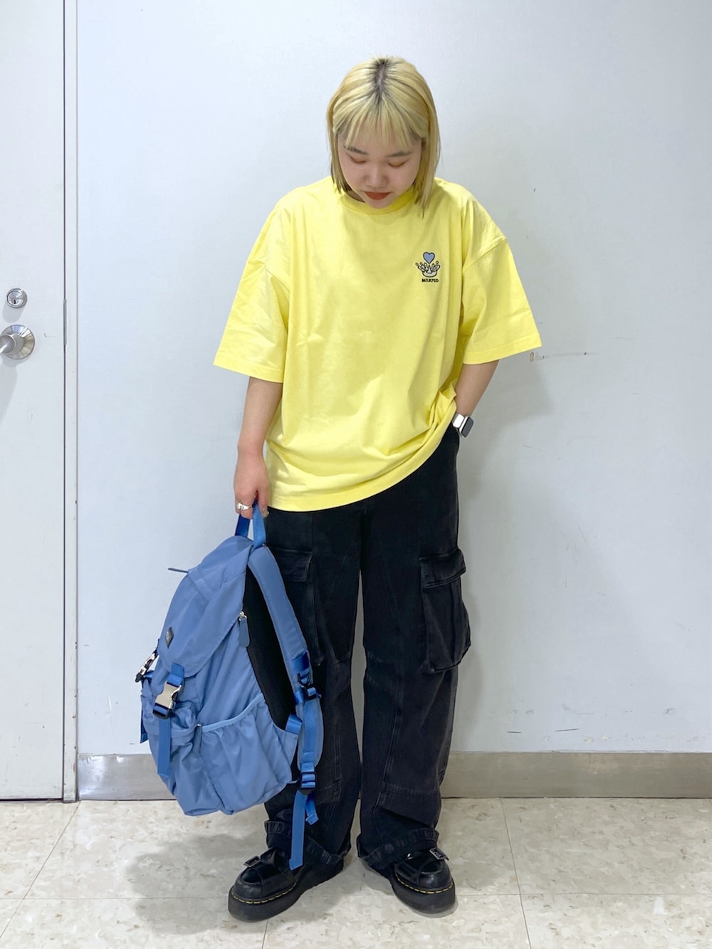 ブラック系のカーゴパンツ、ブルー系のバックパック/リュック、イエロー系のTシャツ/カットソーを着用したレディースの春コーディネートの5枚目の写真