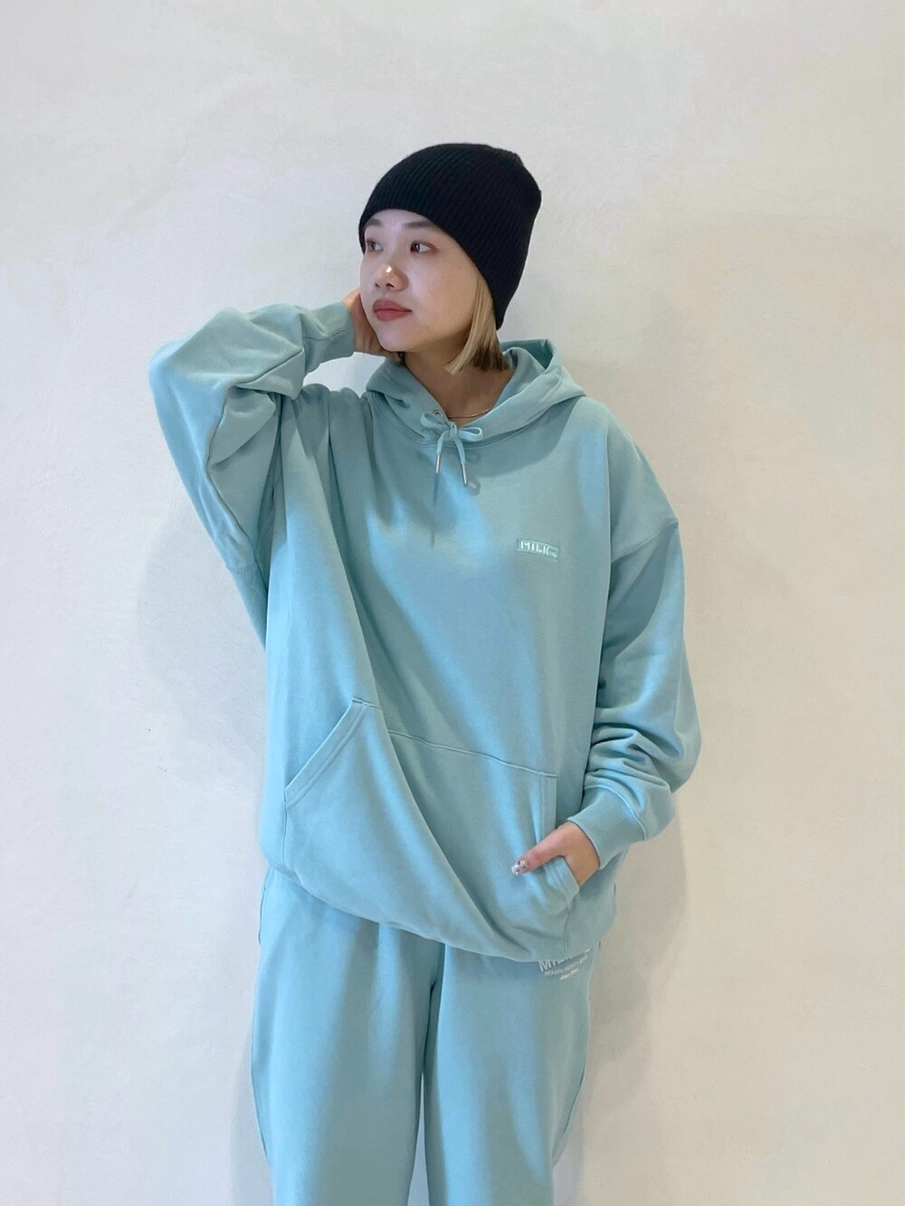 グリーン系のパーカー、グリーン系のスウェットパンツ、ブラック系のバックパック/リュックを着用したレディースの冬コーディネートの6枚目の写真