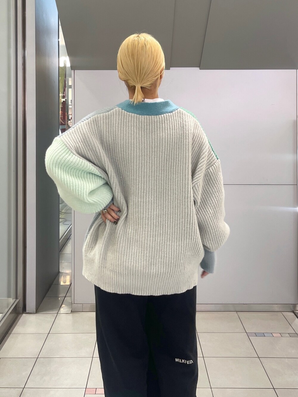 ブラック系のスウェットパンツ、ブルー系のトートバッグ、グリーン系のカーディガン/ボレロを着用したレディースの冬コーディネートの9枚目の写真