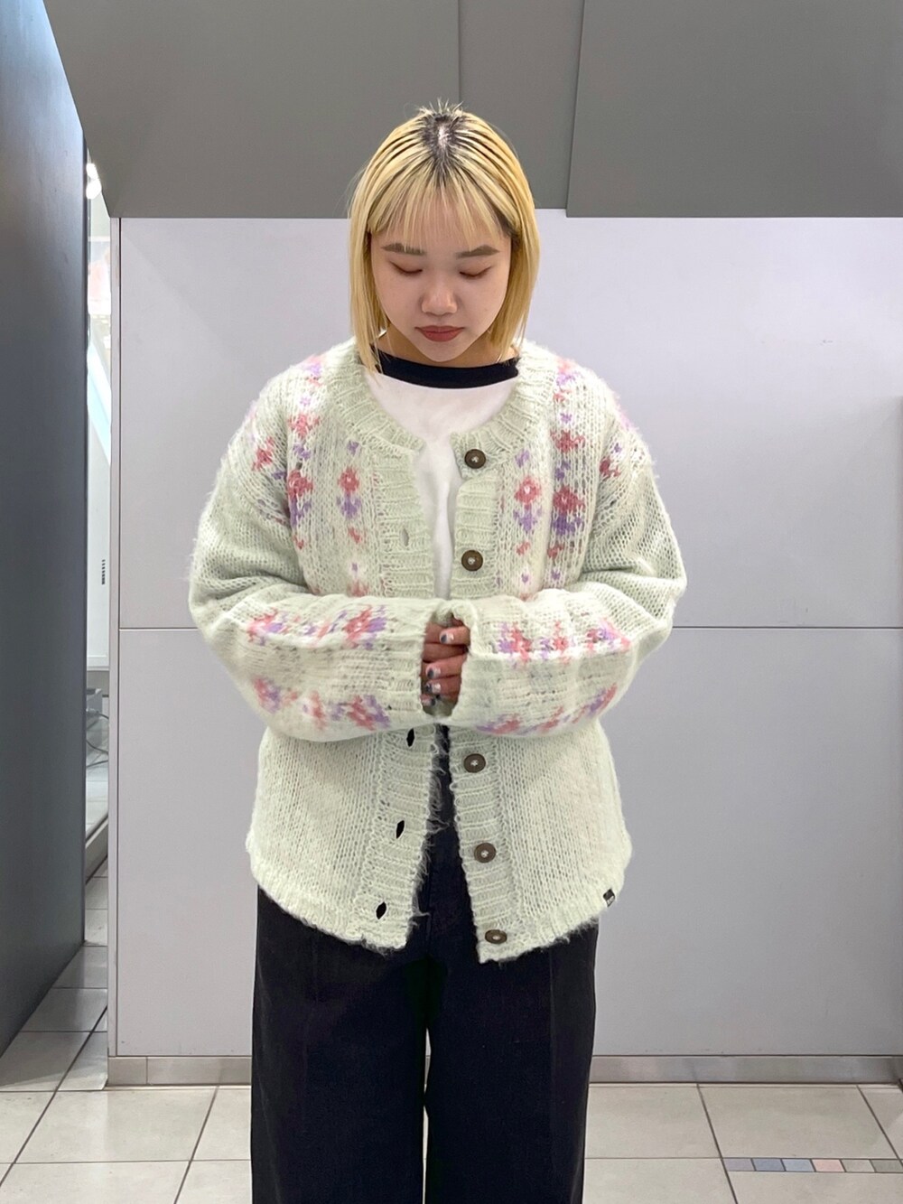ブラック系のデニムパンツ、グリーン系のカーディガン/ボレロ、ブラック系のTシャツ/カットソーを着用したレディースの冬コーディネートの6枚目の写真
