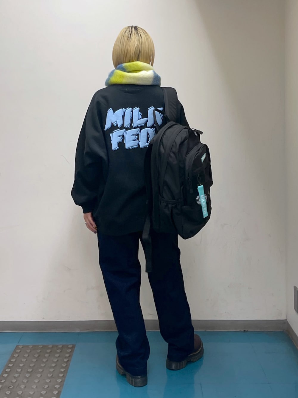 ブルー系のデニムパンツ、グリーン系のバックパック/リュック、ブラック系のスウェットを着用したレディースの秋コーディネートの4枚目の写真