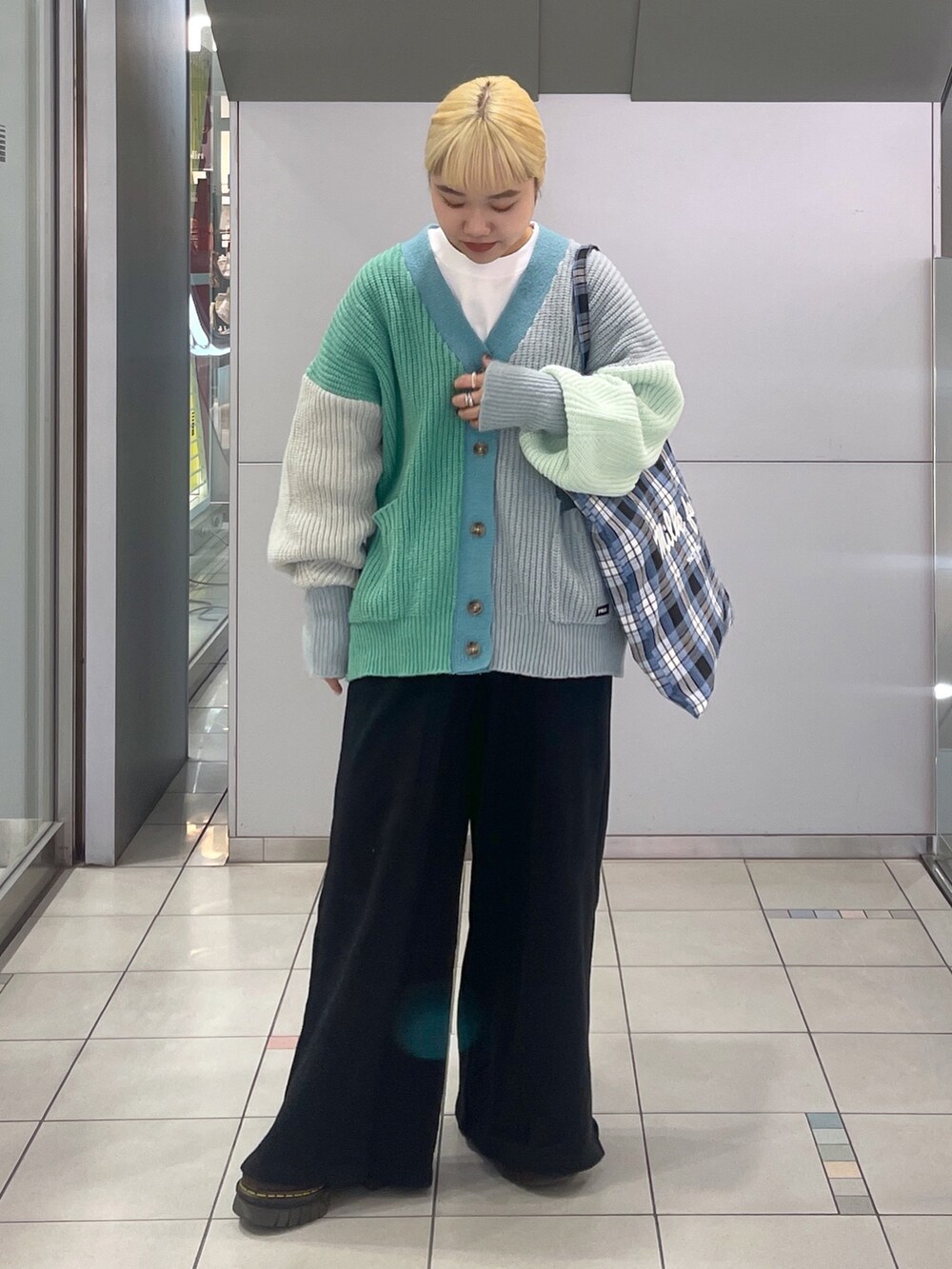 ブラック系のスウェットパンツ、ブルー系のトートバッグ、グリーン系のカーディガン/ボレロを着用したレディースの冬コーディネートの2枚目の写真