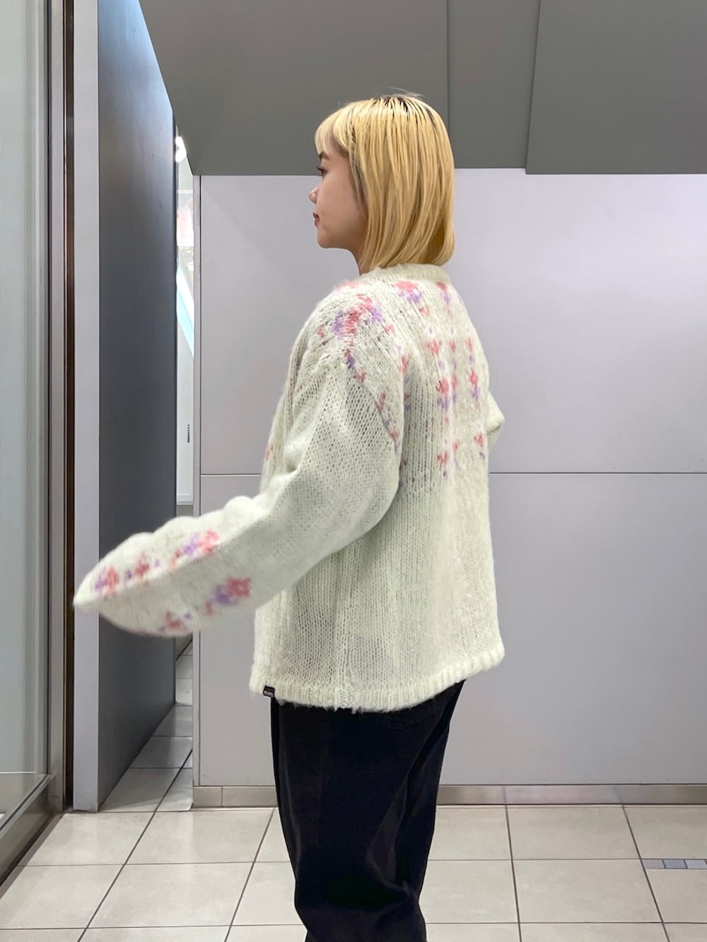 ブラック系のデニムパンツ、グリーン系のカーディガン/ボレロ、ブラック系のTシャツ/カットソーを着用したレディースの冬コーディネートの7枚目の写真