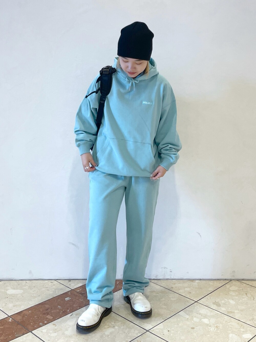 グリーン系のパーカー、グリーン系のスウェットパンツ、ブラック系のバックパック/リュックを着用したレディースの冬コーディネートの2枚目の写真