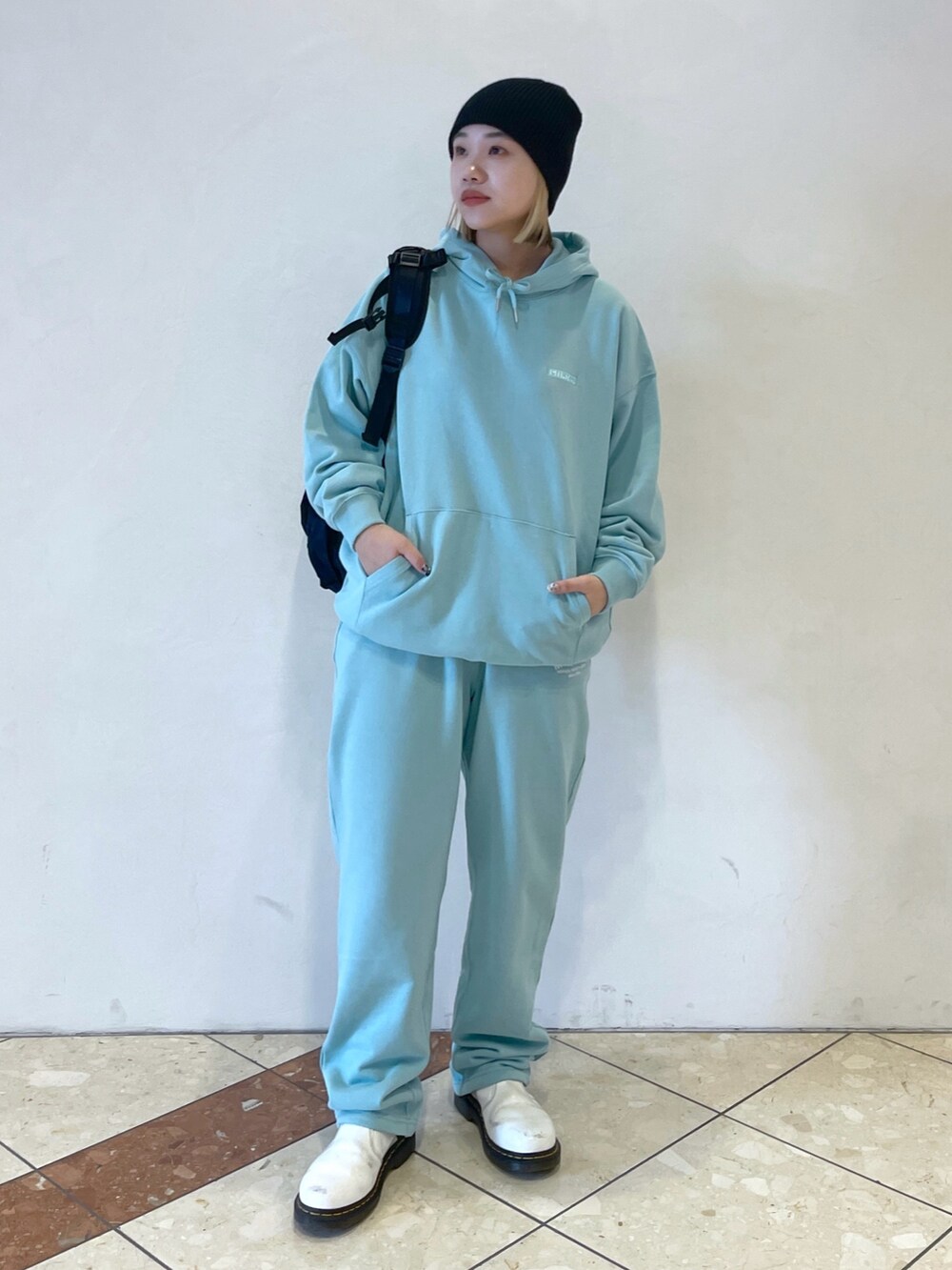 グリーン系のパーカー、グリーン系のスウェットパンツ、ブラック系のバックパック/リュックを着用したレディースの冬コーディネートの3枚目の写真