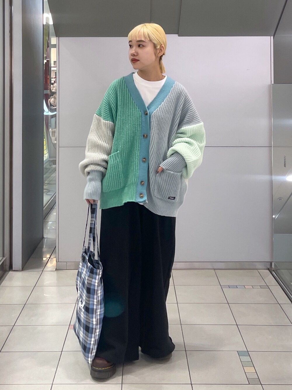 ブラック系のスウェットパンツ、ブルー系のトートバッグ、グリーン系のカーディガン/ボレロを着用したレディースの冬コーディネートの3枚目の写真