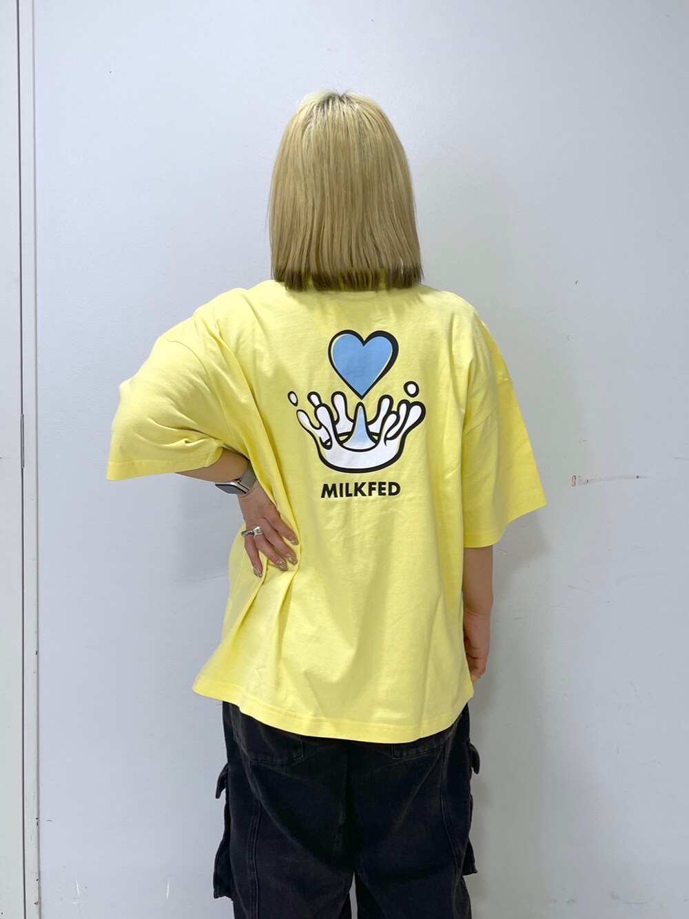 ブラック系のカーゴパンツ、ブルー系のバックパック/リュック、イエロー系のTシャツ/カットソーを着用したレディースの春コーディネートの8枚目の写真
