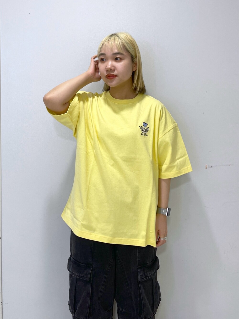 ブラック系のカーゴパンツ、ブルー系のバックパック/リュック、イエロー系のTシャツ/カットソーを着用したレディースの春コーディネートの6枚目の写真