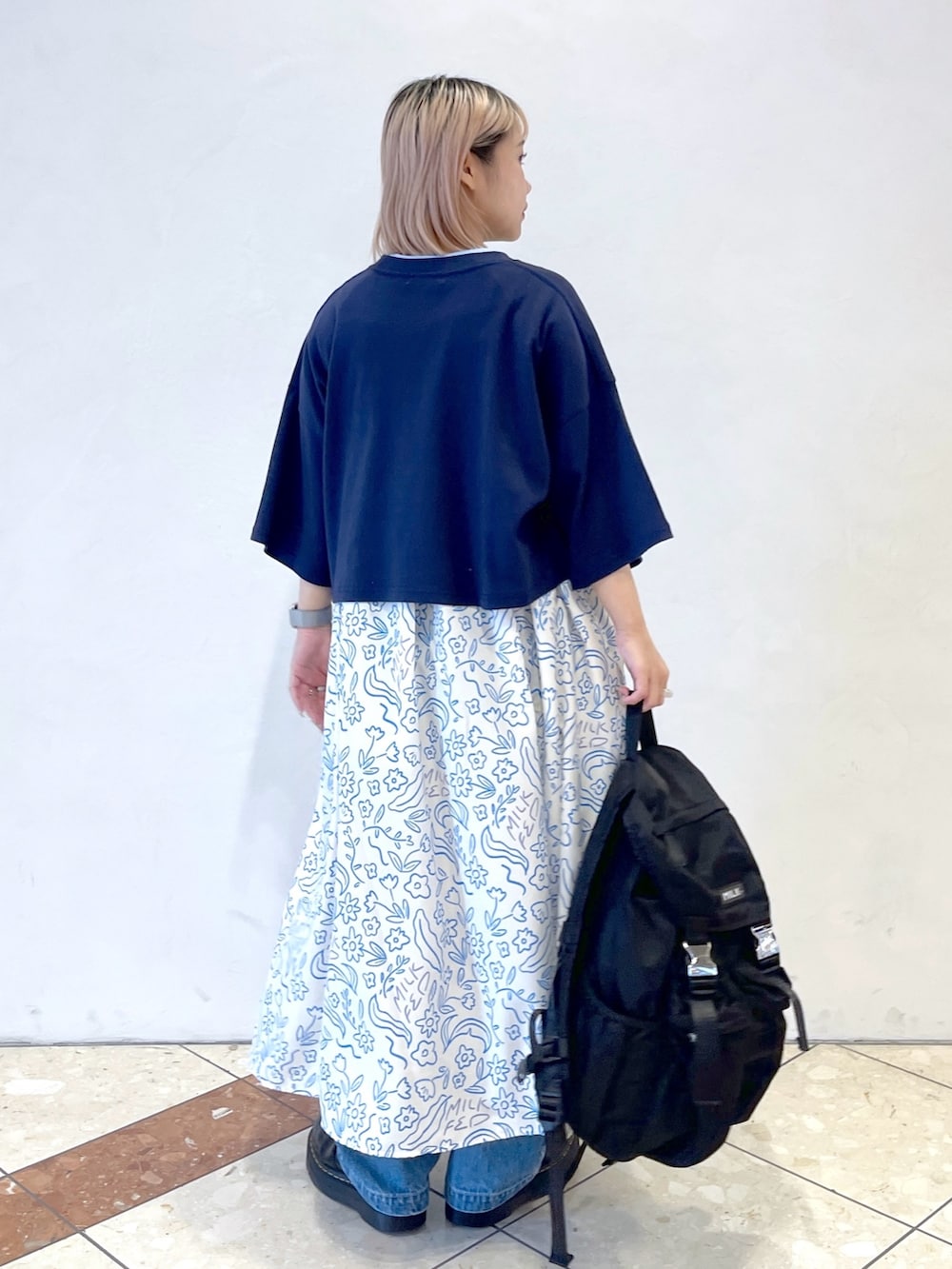 ホワイト系のワンピース、ブルー系のTシャツ/カットソー、ブラック系のブーツを着用したレディースの夏コーディネートの4枚目の写真