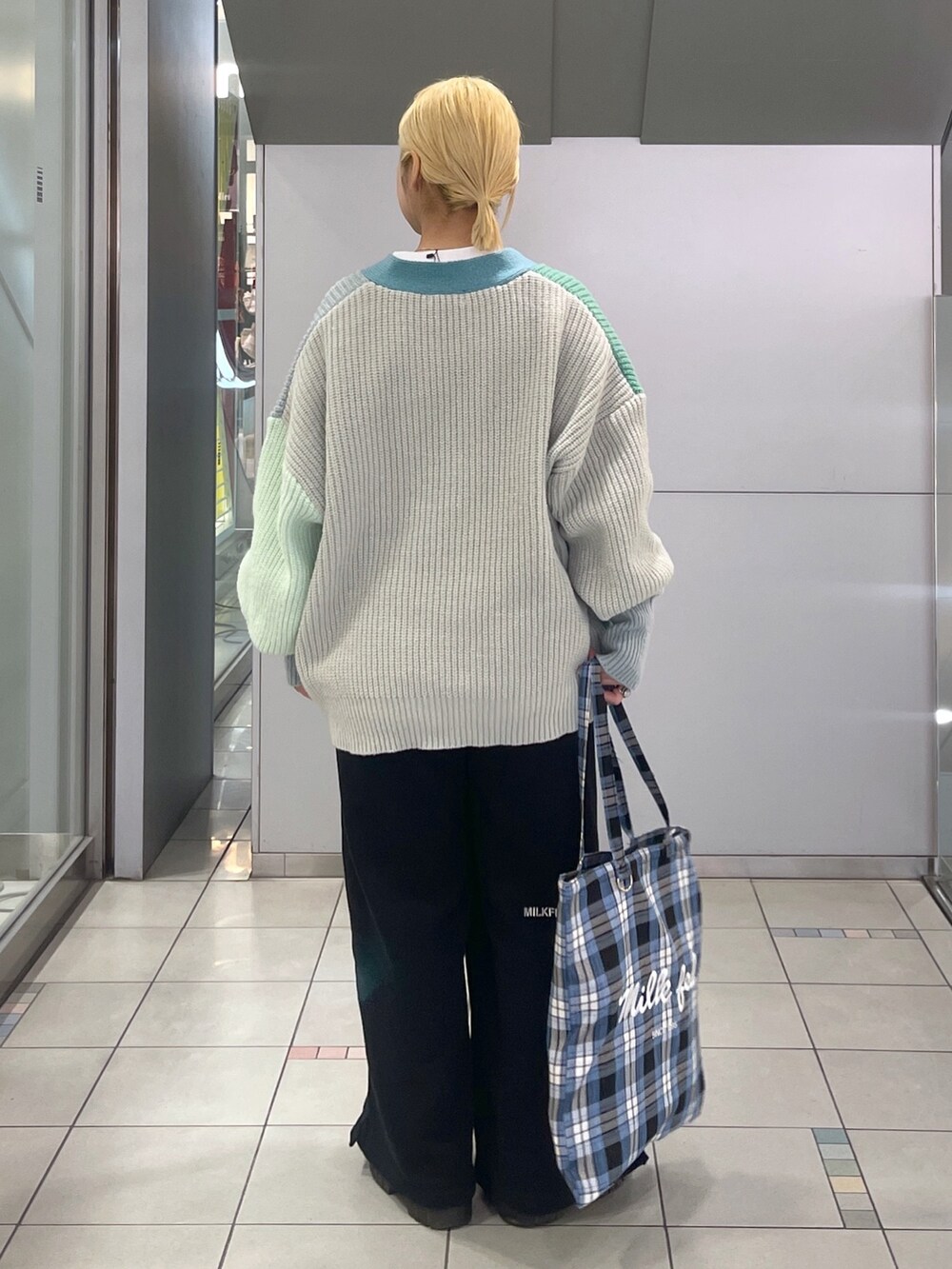 ブラック系のスウェットパンツ、ブルー系のトートバッグ、グリーン系のカーディガン/ボレロを着用したレディースの冬コーディネートの4枚目の写真