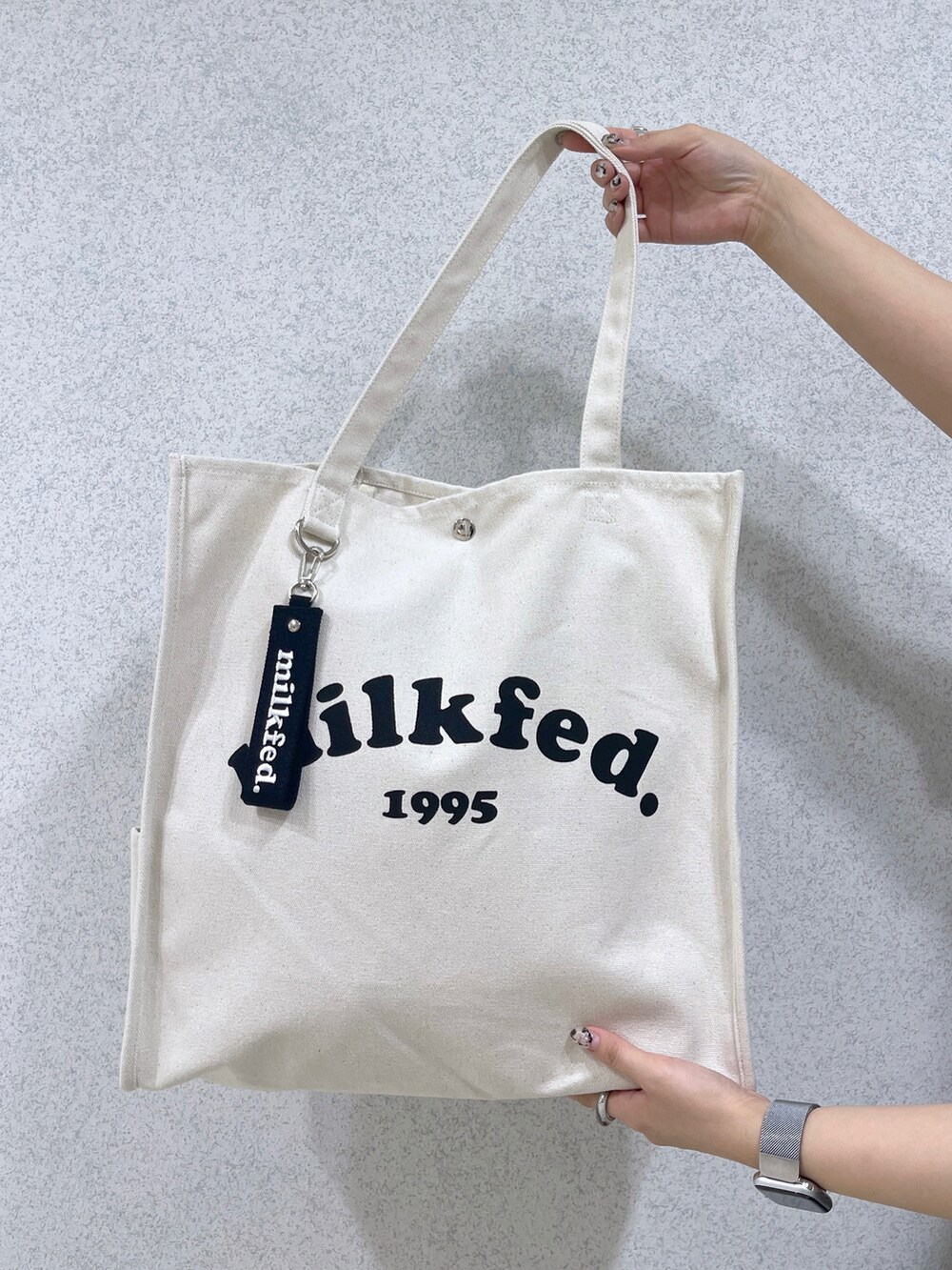 ホワイト系のトートバッグ、ブルー系のワンピース、ホワイト系のシャツ/ブラウスを着用したレディースの夏コーディネートの4枚目の写真