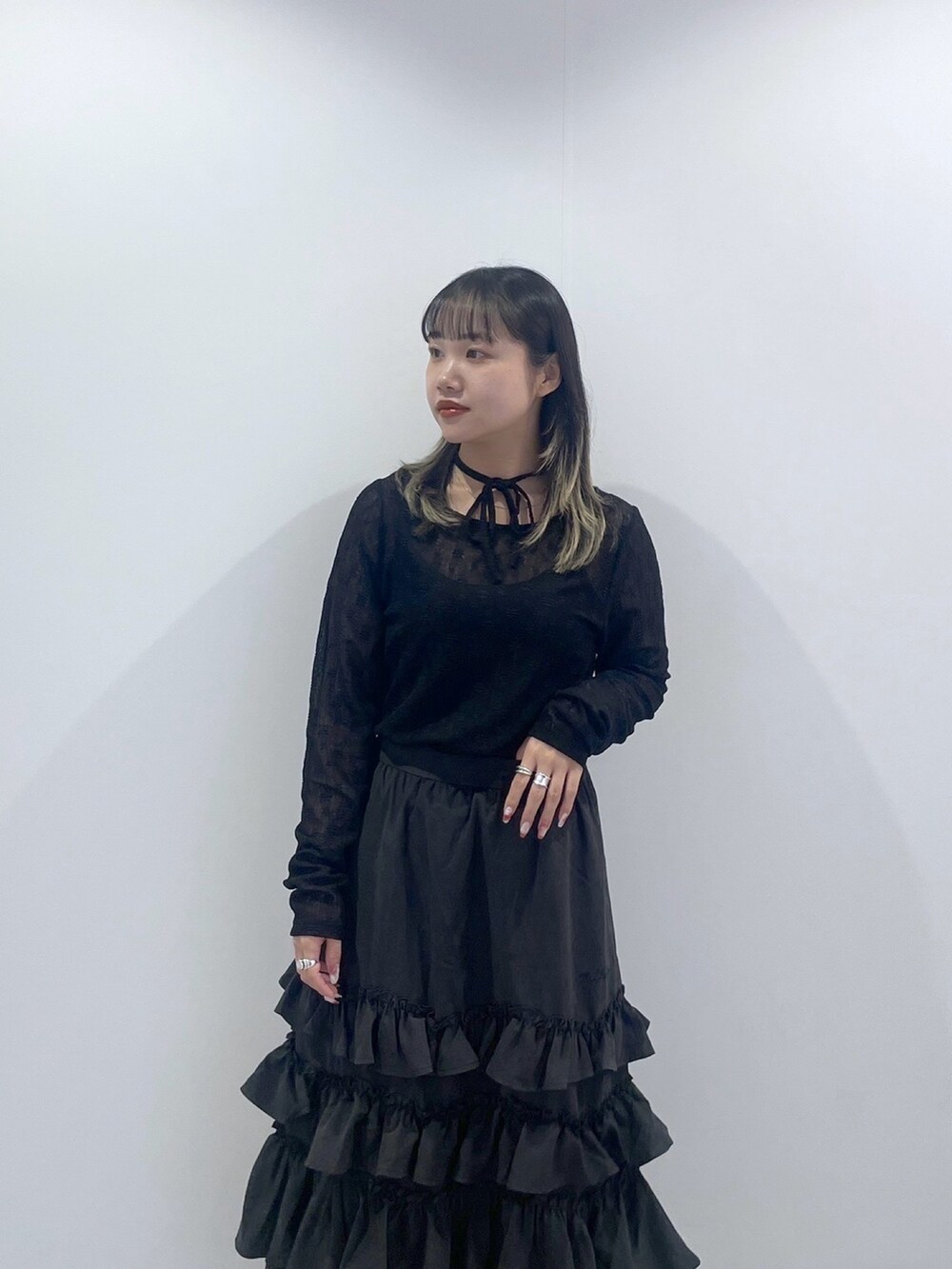 ブラック系のTシャツ/カットソー、ブラック系のスカート、ホワイト系のハンドバッグを着用したレディースの秋コーディネートの7枚目の写真