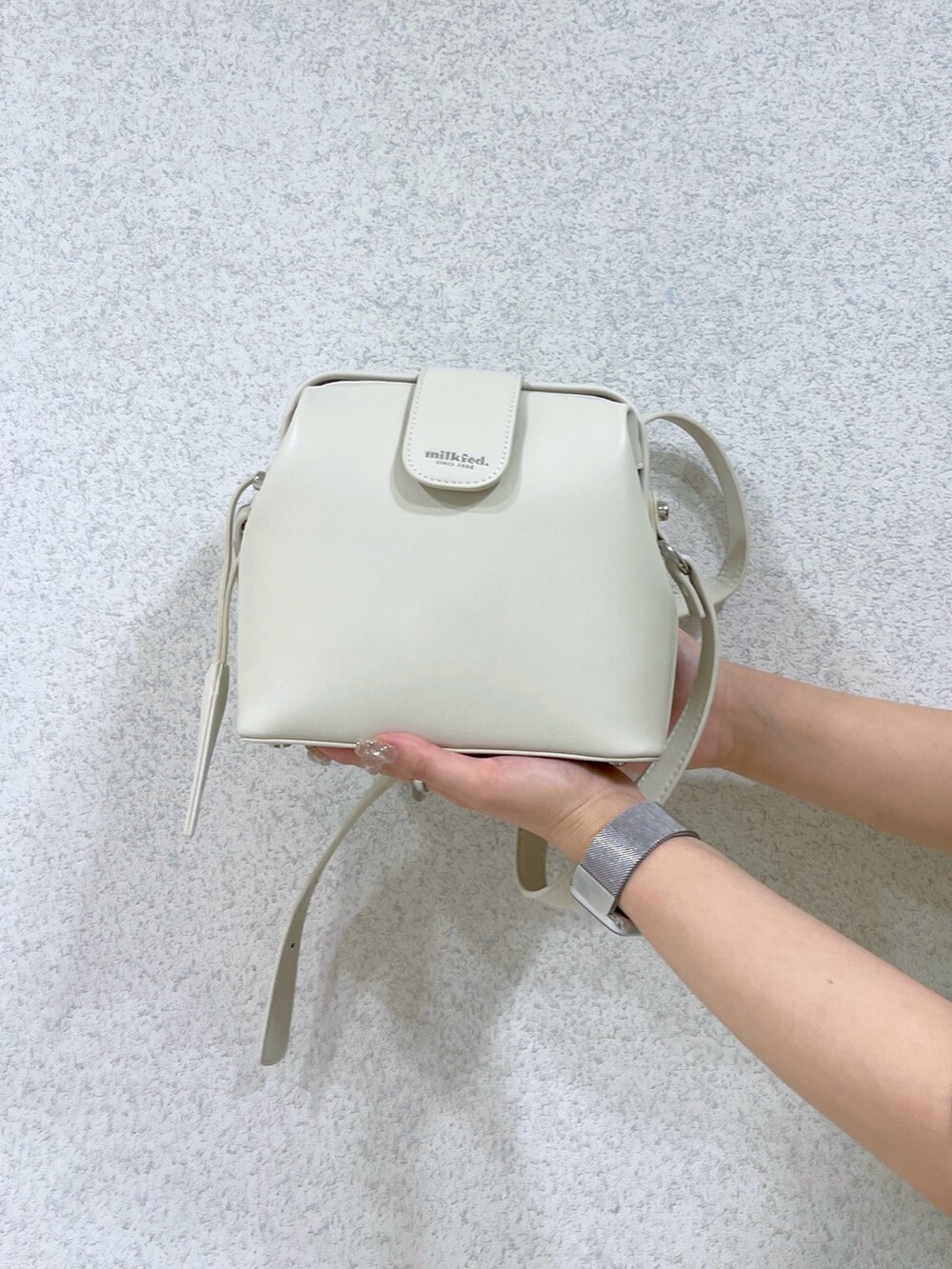 イエロー系のベスト、ホワイト系のショルダーバッグ、ブラック系のカーゴパンツを着用したレディースの春コーディネートの8枚目の写真