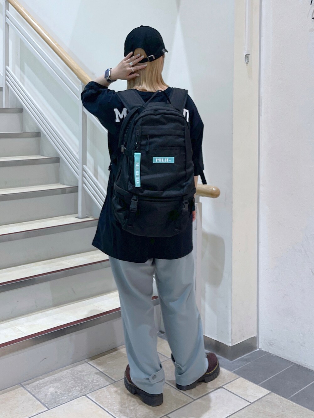 ブルー系のその他パンツ、ブラック系のTシャツ/カットソー、ブラック系のバックパック/リュックを着用したレディースの春コーディネートの2枚目の写真